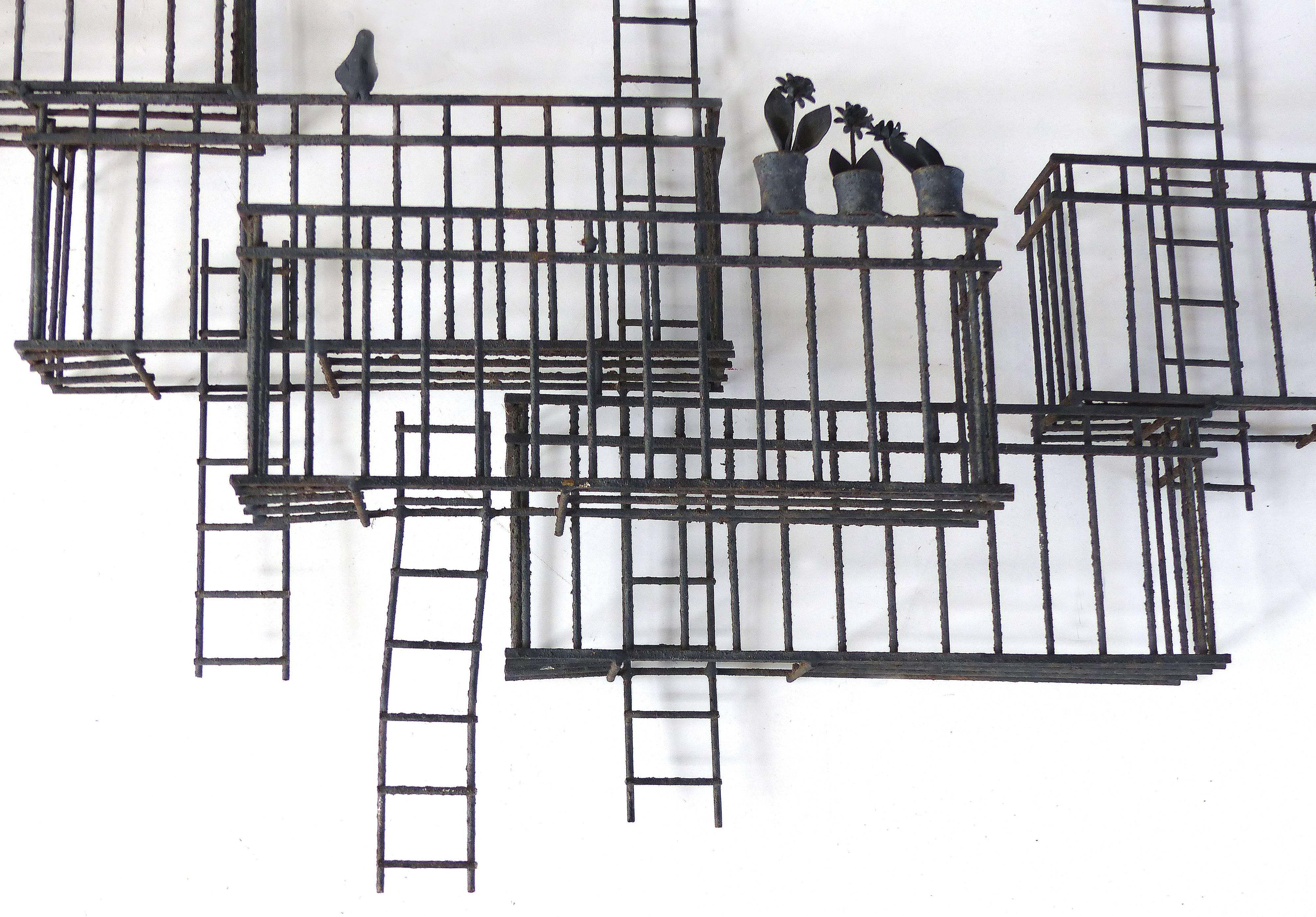 Offered for sale is a large 1970s vintage studio metal wall sculpture created in the style of Ilana Goor. The brutalist sculpture represents cityscape balconies and fire escapes with birds and potted plants. The sculpture has great movement and