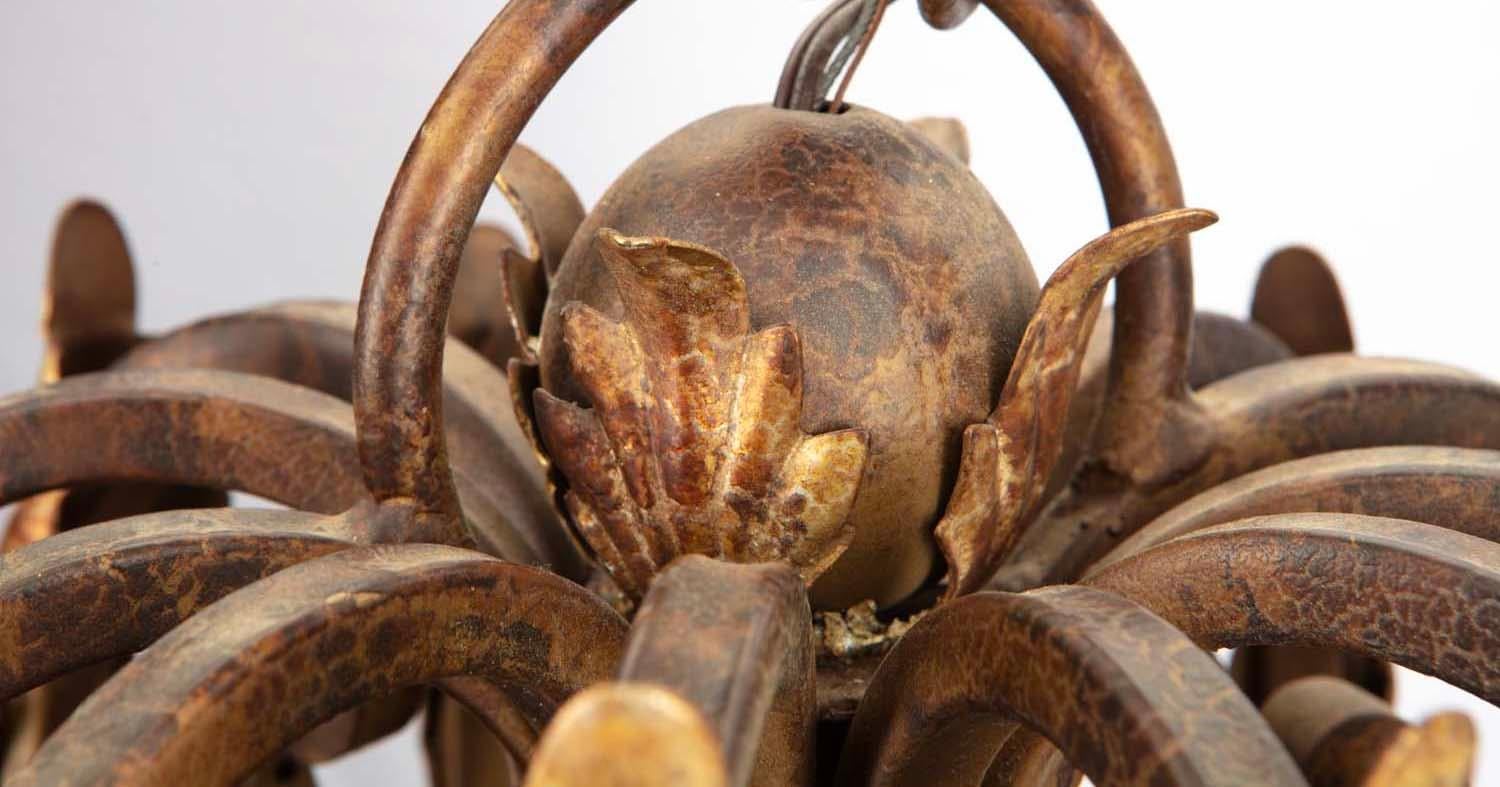 Realizzato per l'ingresso di un castello, questo lampadario patinato di grandi dimensioni attira l'attenzione con le sue audaci spirali forgiate e le foglie d'acanto ricoperte di lamina dorata. Quattordici candele collegate all'elettricità