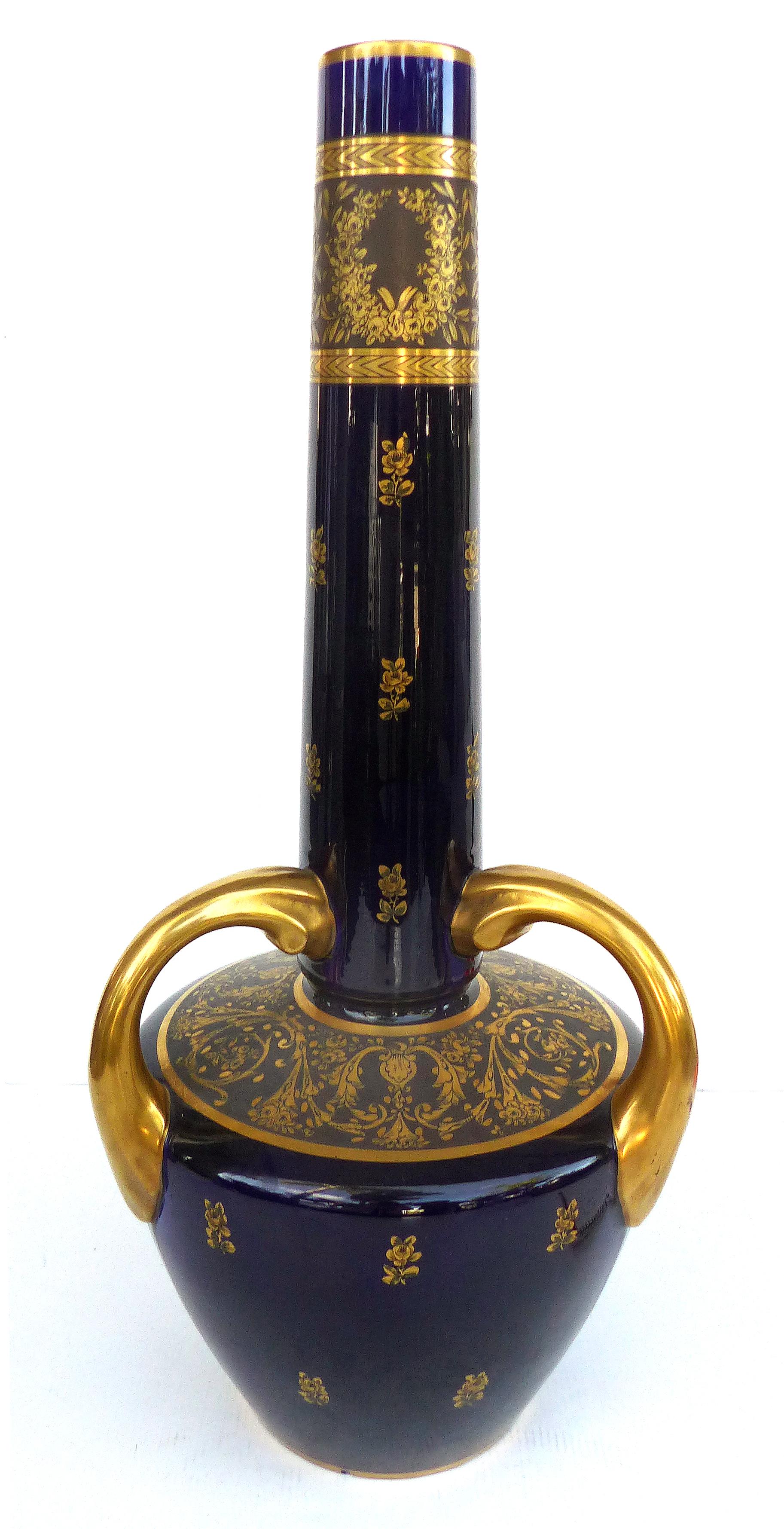 Overscale antique Sèvres Porcelain urn vases in cobalt blue with gilt accents

Offered for sale is a striking pair of overscale cobalt blue handled Sèvres Porcelain urn vases with gilt accents. The pair is from the turn-of-the-century and each is