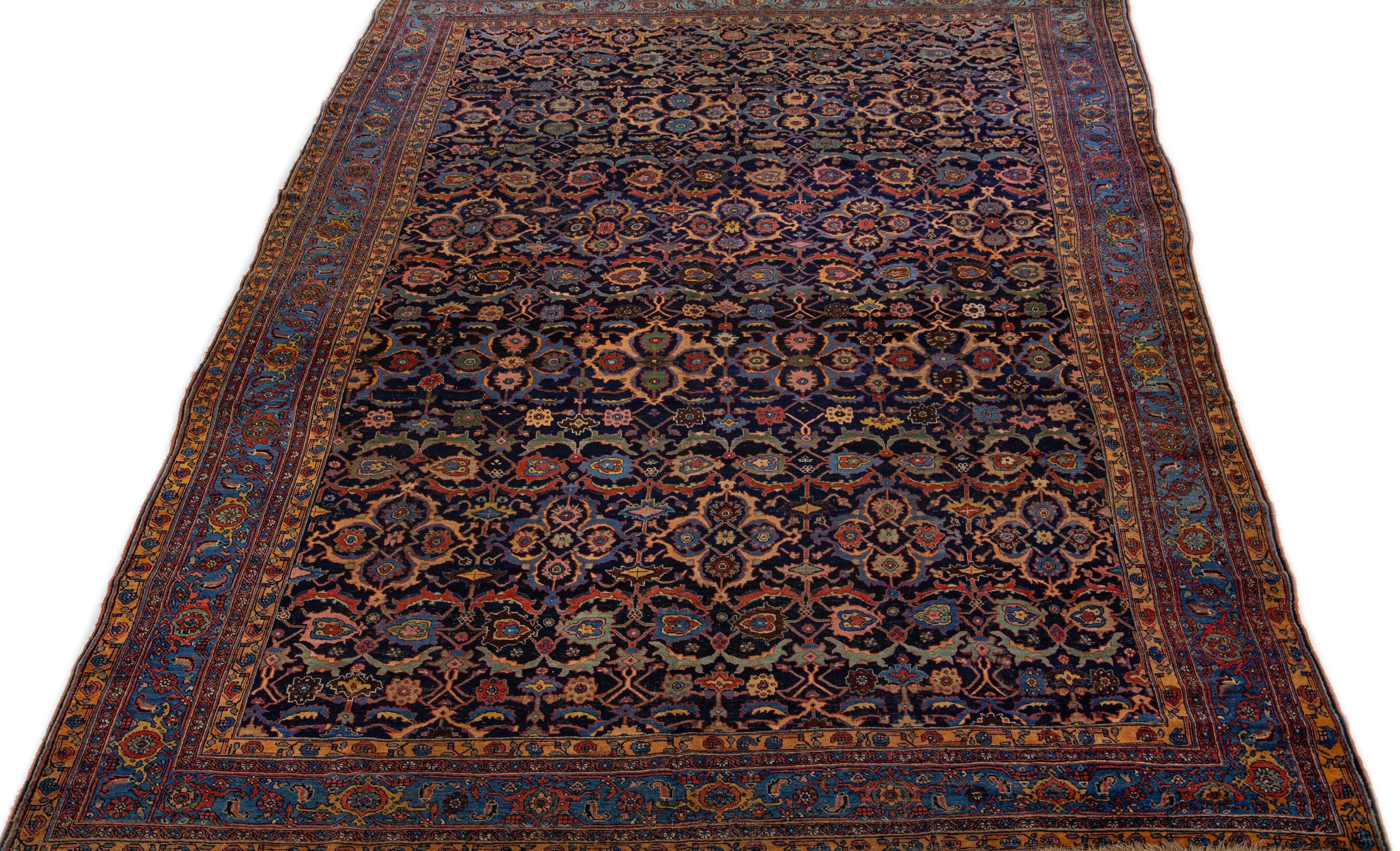 This stunning Bidjar wool rug showcases a dark blue color field, featuring an exquisite traditional floral design with rust, green, and yellow accents. The piece is crafted with great attention to detail, portraying the fine craftsmanship of Persian