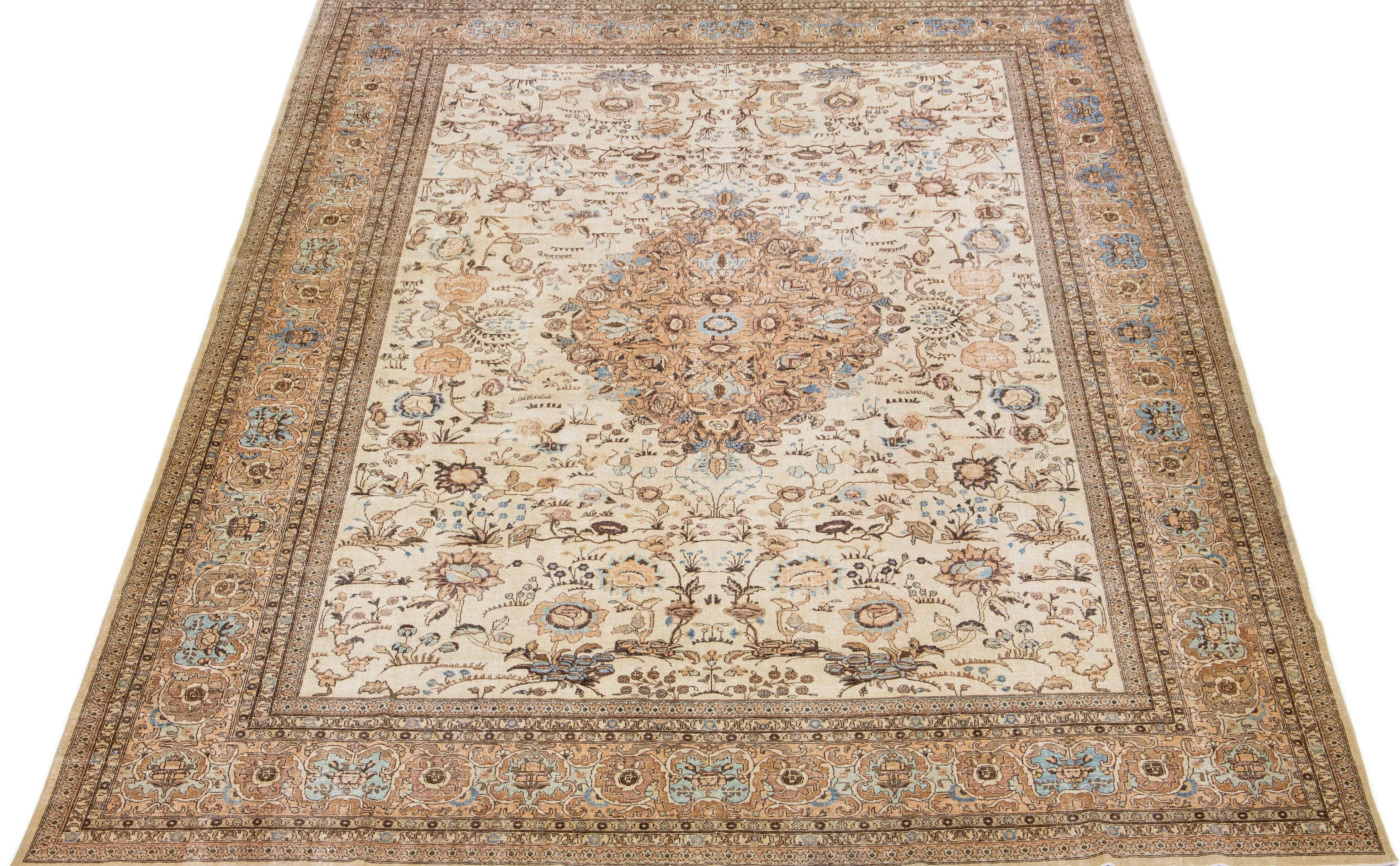 Beautiful antique Persian hand-knotted wool rug with a beige color field. This piece has a tan-designed frame with blue and brown accents in a gorgeous medallion design.

This rug measures: 11'6' x 16'.

Our rugs are professional cleaning before