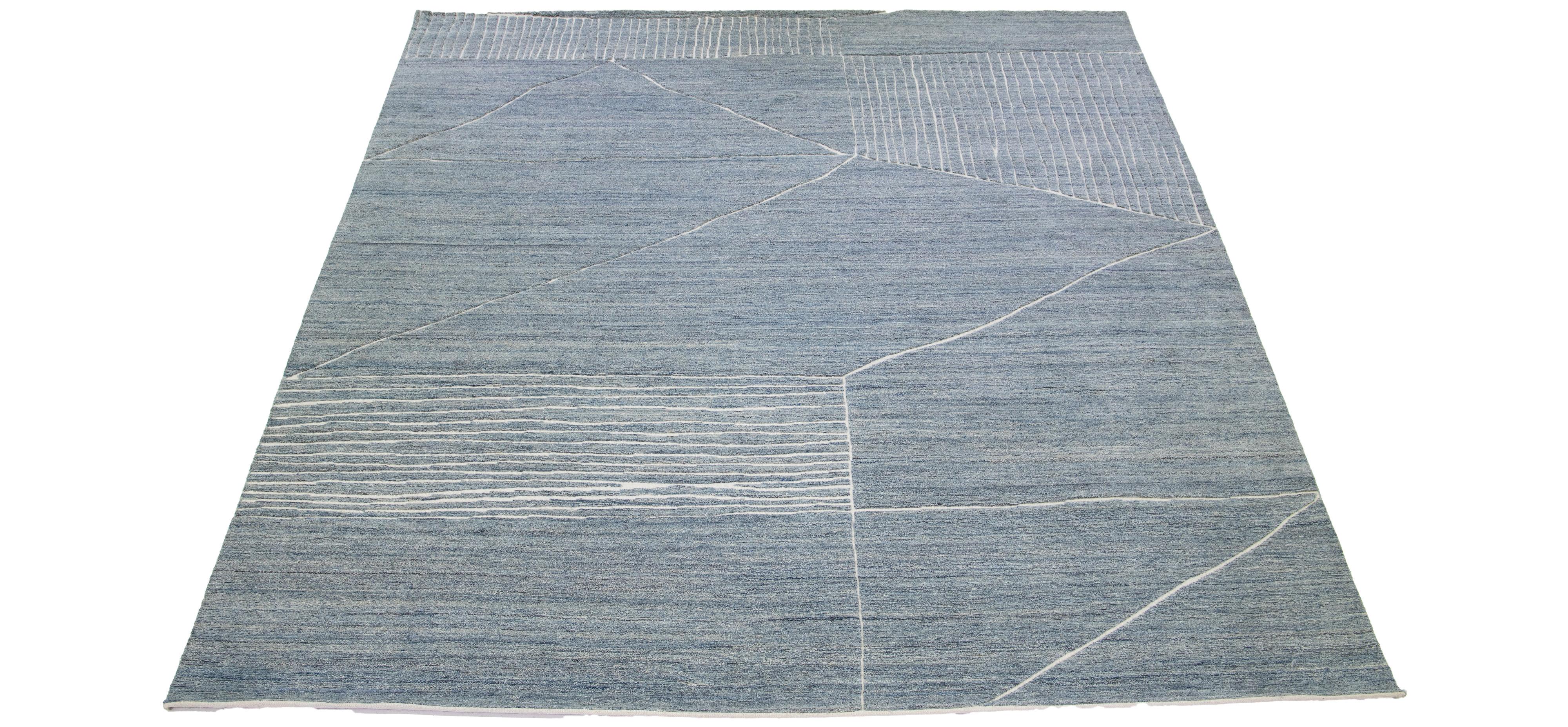 This luxurious wool rug features a timeless Moroccan pattern in a contemporary abstract Minimalist style, utilizing blue tones to create a sleek and modern look. It is crafted using traditional hand-knotting techniques, ensuring exceptional quality