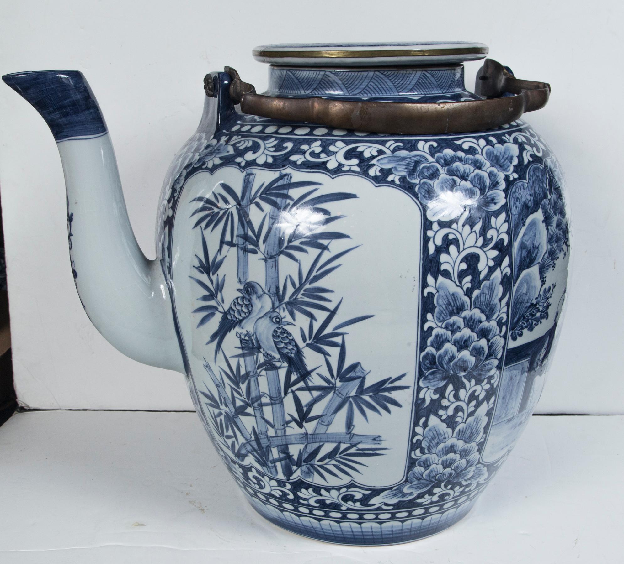 Blue and white ornamental tea pot with brass swing handle. Labeled on the bottom Maitland-Smith. Decorated with fish, birds and bamboo.
The spout sticks out about 4 inches from the body.
  