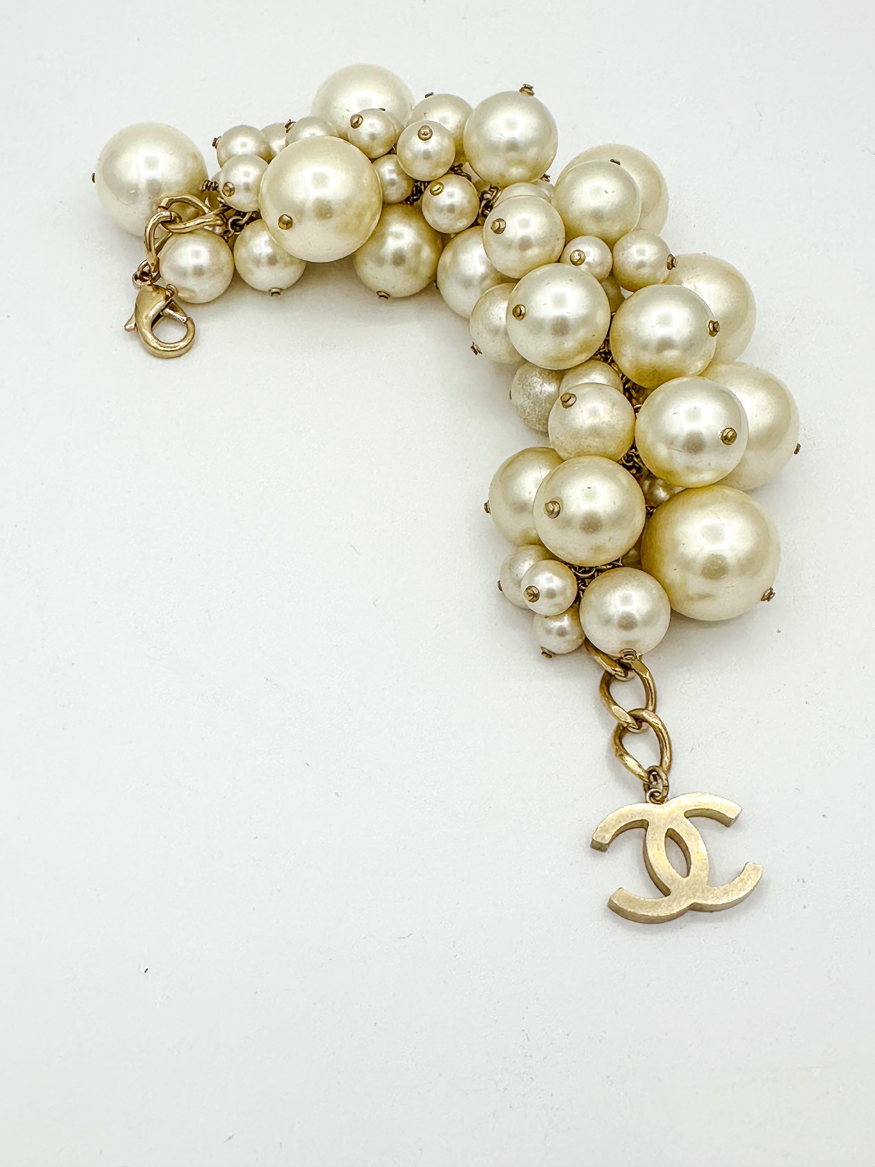 Übergroßes Chanel Frühjahr 2013 Runway Perlenarmband.  Gebürstetes, goldfarbenes Metallkettenglied mit unterschiedlich großen Perlen; ikonischer CC-Logo-Charme 

Messung Länge: 28cm
Die Größe der Perlen variiert von 25 mm im Durchmesser 1 Perle, 2