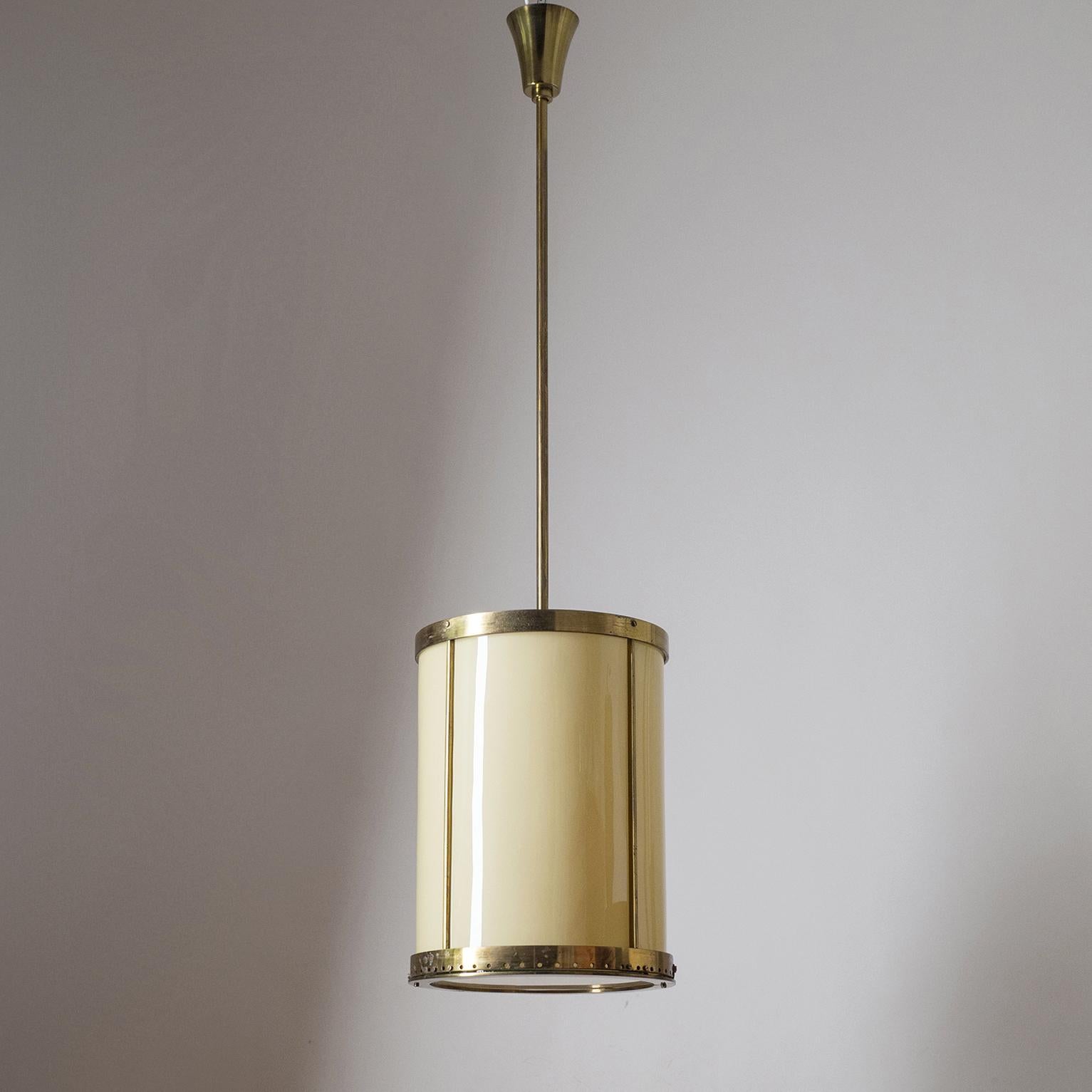 Rare oversize drum lantern from the 1930s. Minimalist brass-plated steel structure with sand-colored curved glass. Bottom glass has a white casing, top glass segments are frosted. One ceramic E40 socket (for industrial strength bulbs).