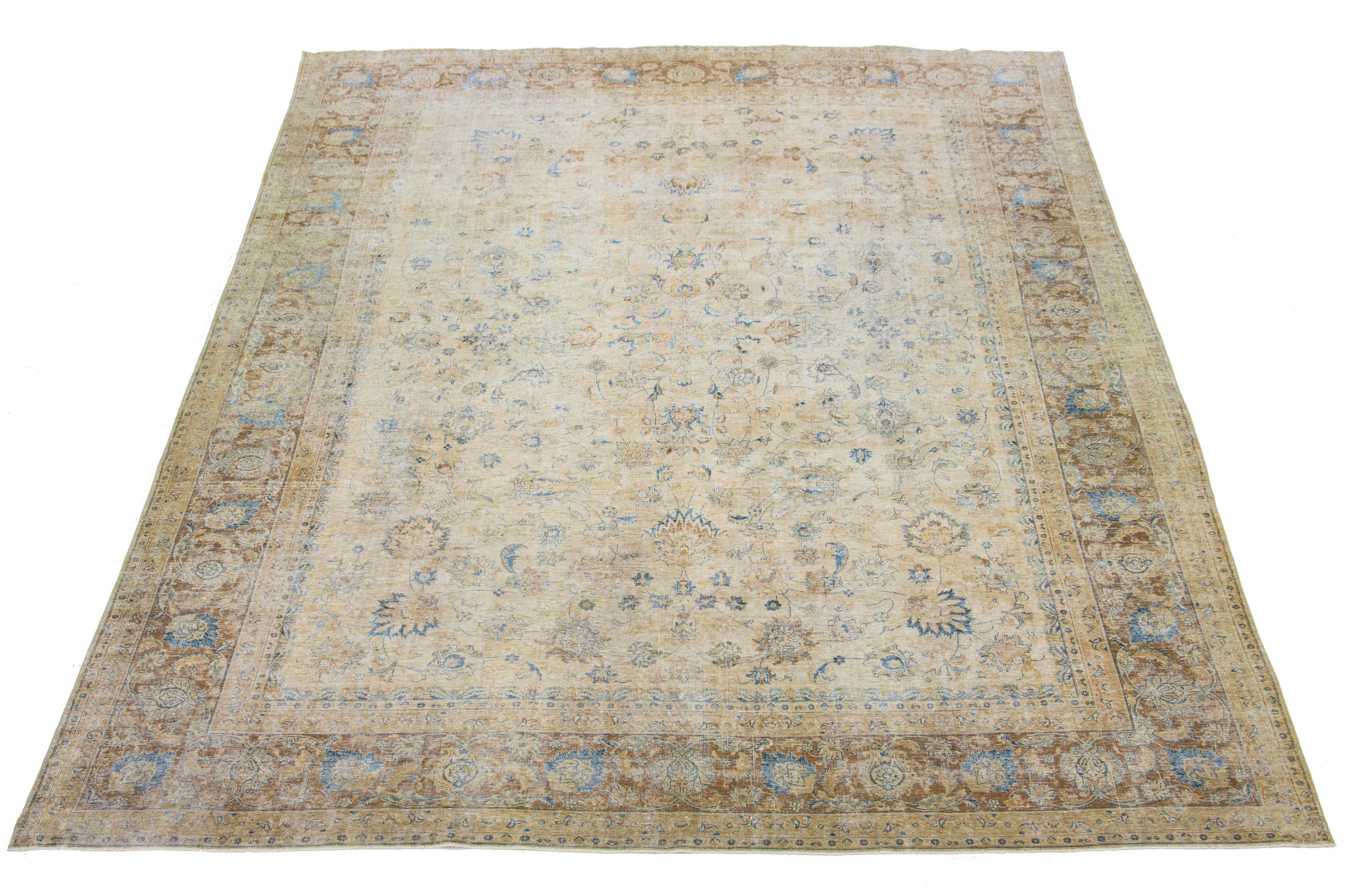 Dieser handgefertigte persische Wollteppich aus Täbris zeigt ein traditionelles Blumenmuster. Der Kontrast zwischen dem braunen und beigen Hintergrund unterstreicht das blaue Blumenmuster.

Dieser Teppich misst 11'4