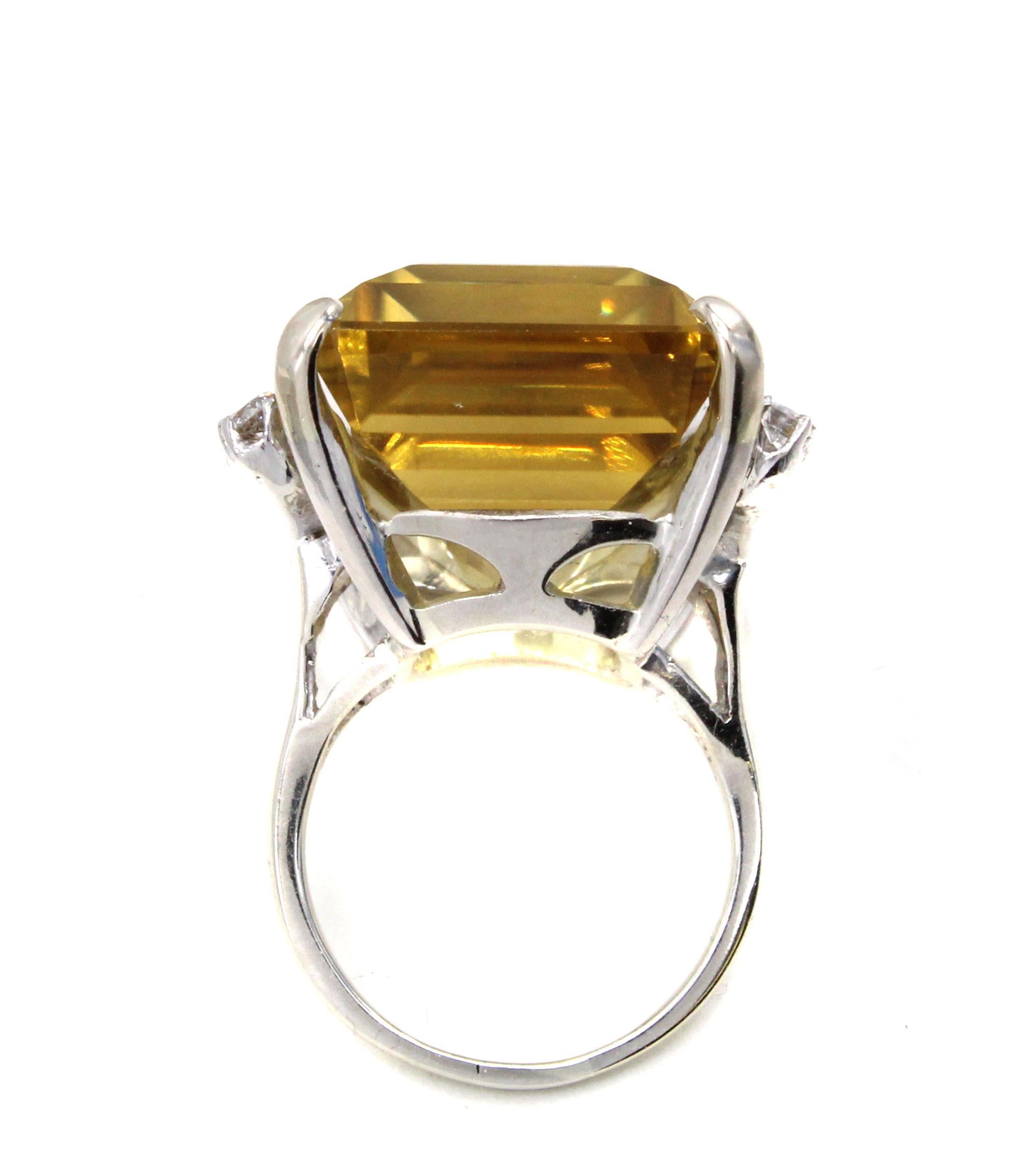 Centrally set with a Golden Citrine measured to weigh approximately 35 carats this bold 1960s ring is a real eye-catcher. The perfectly cut emerald cut Citrine exhibits a beautiful saturation of color and fire. 6 bright white round brilliant cut