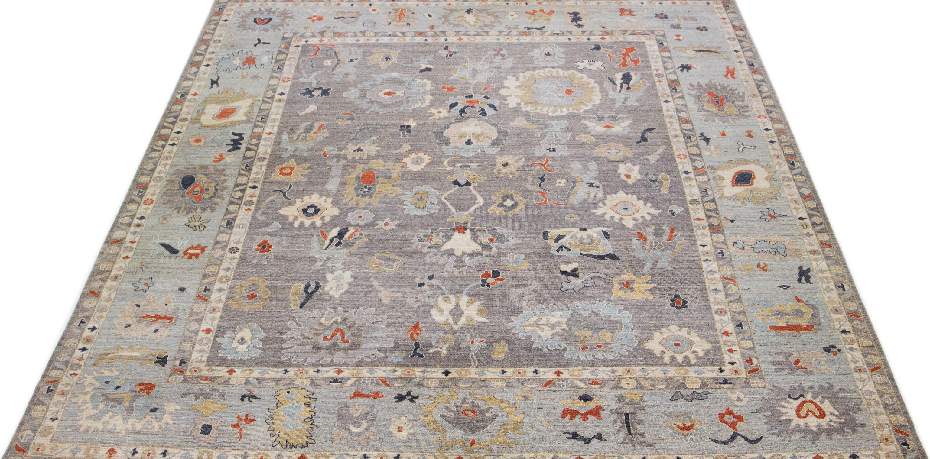 Our Gray Field Oushak style rug features an all-over floral design with handmade quality and hand knotted techniques. Made with 100% wool, this Indian rug features rust, beige, and blue accents for a touch of color.

This rug measures 11'11