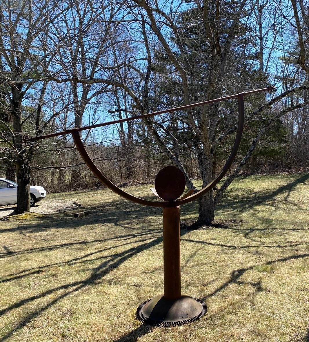 Make a statement with this large scale steel garden armillary with arrow and half round shape representing a part of the constellation encircling a round disc, a part of the solar system. This impressive nearly 8' tall and 9.5 feet wide sculpture