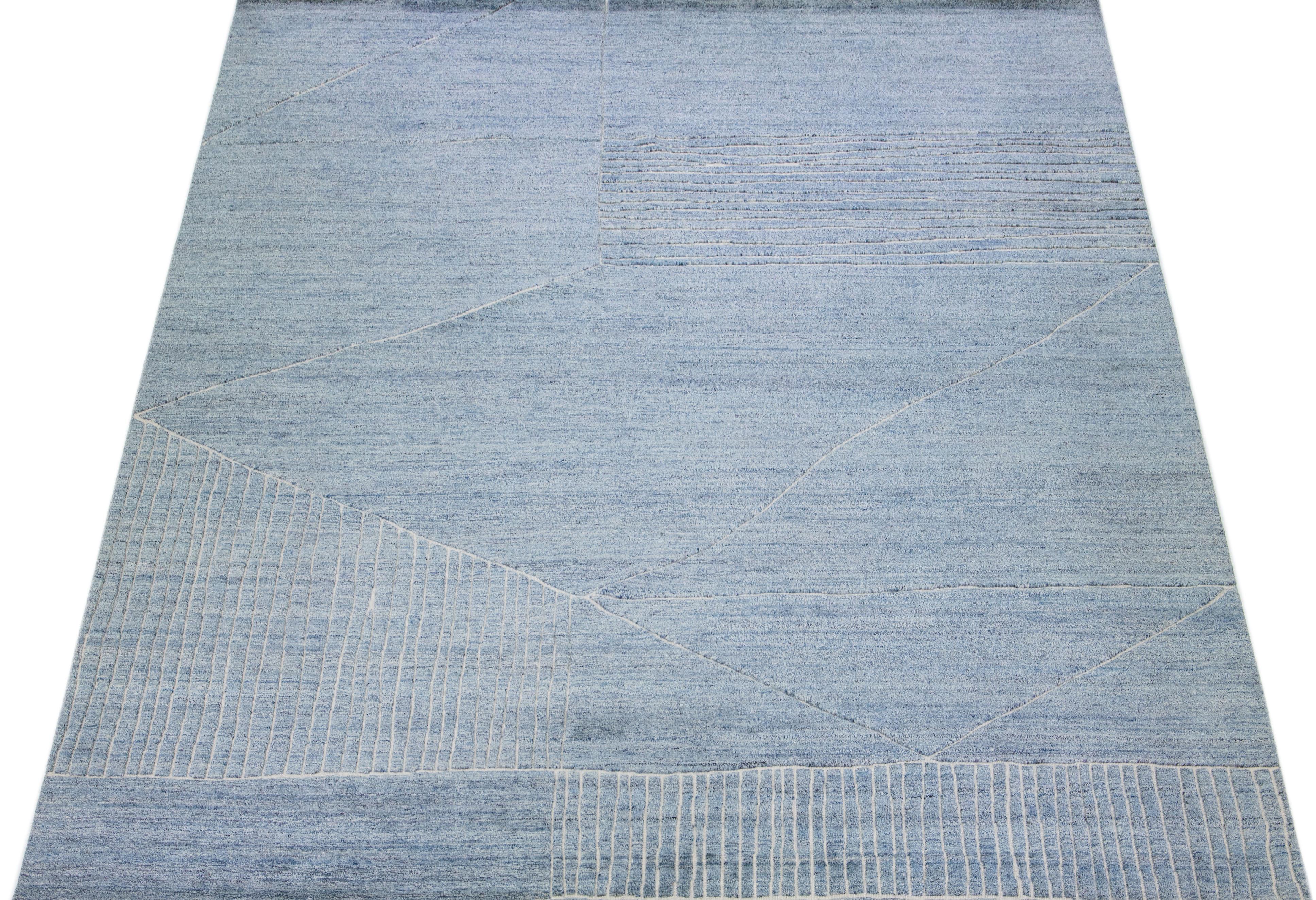 Beautiful modern Moroccan-style hand-knotted wool rug with a light blue color field. This rug is part of our Apadana's Safi Collection and features a geometric design in white.

This rug measures: 12'1