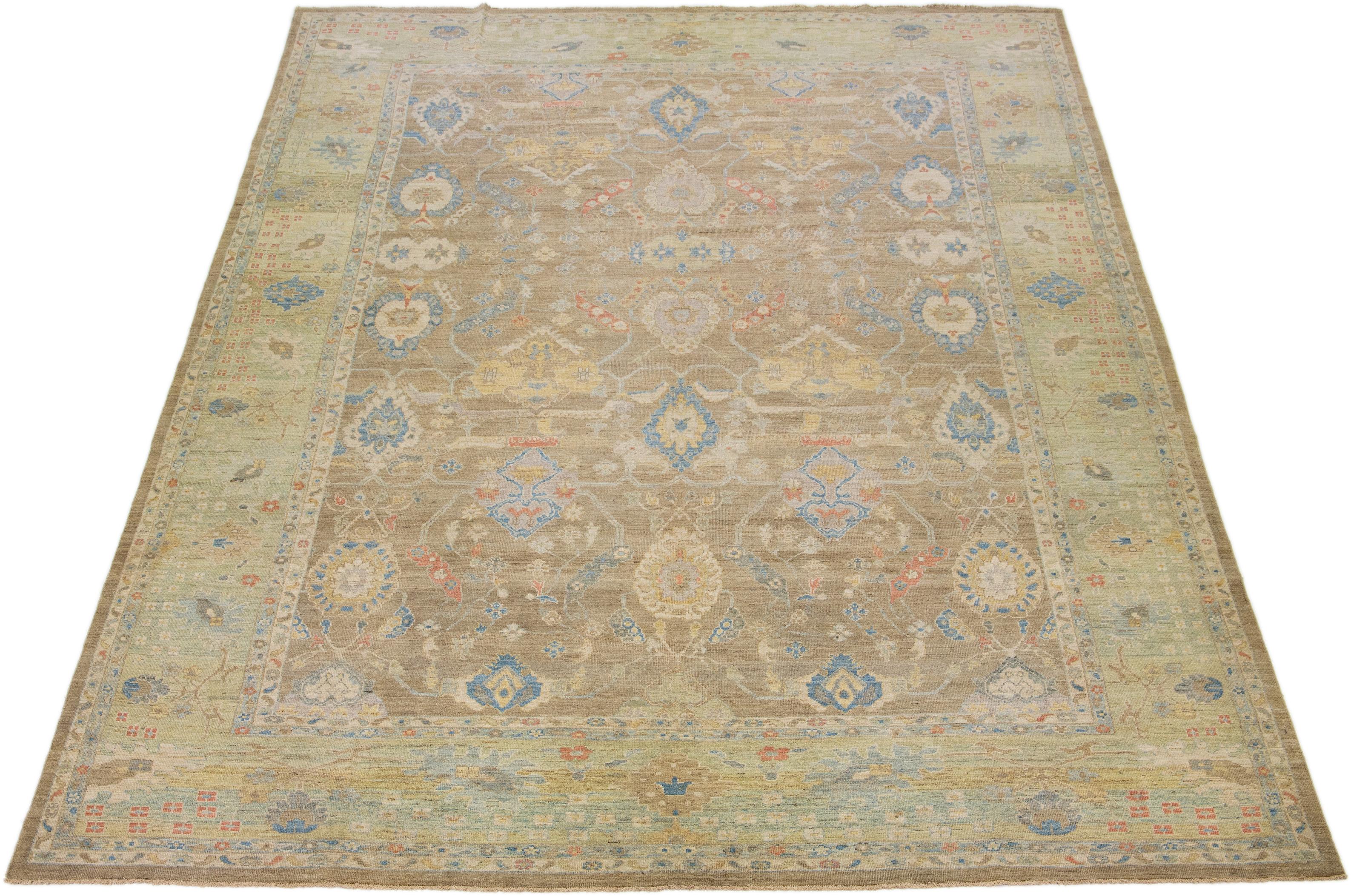 This modern reinterpretation of timeless Sultanabad design is beautifully manifested in an exquisitely hand-knotted wool rug, resplendent in its striking light brown shade. An intricate green border delineates its all-over floral embroidery,