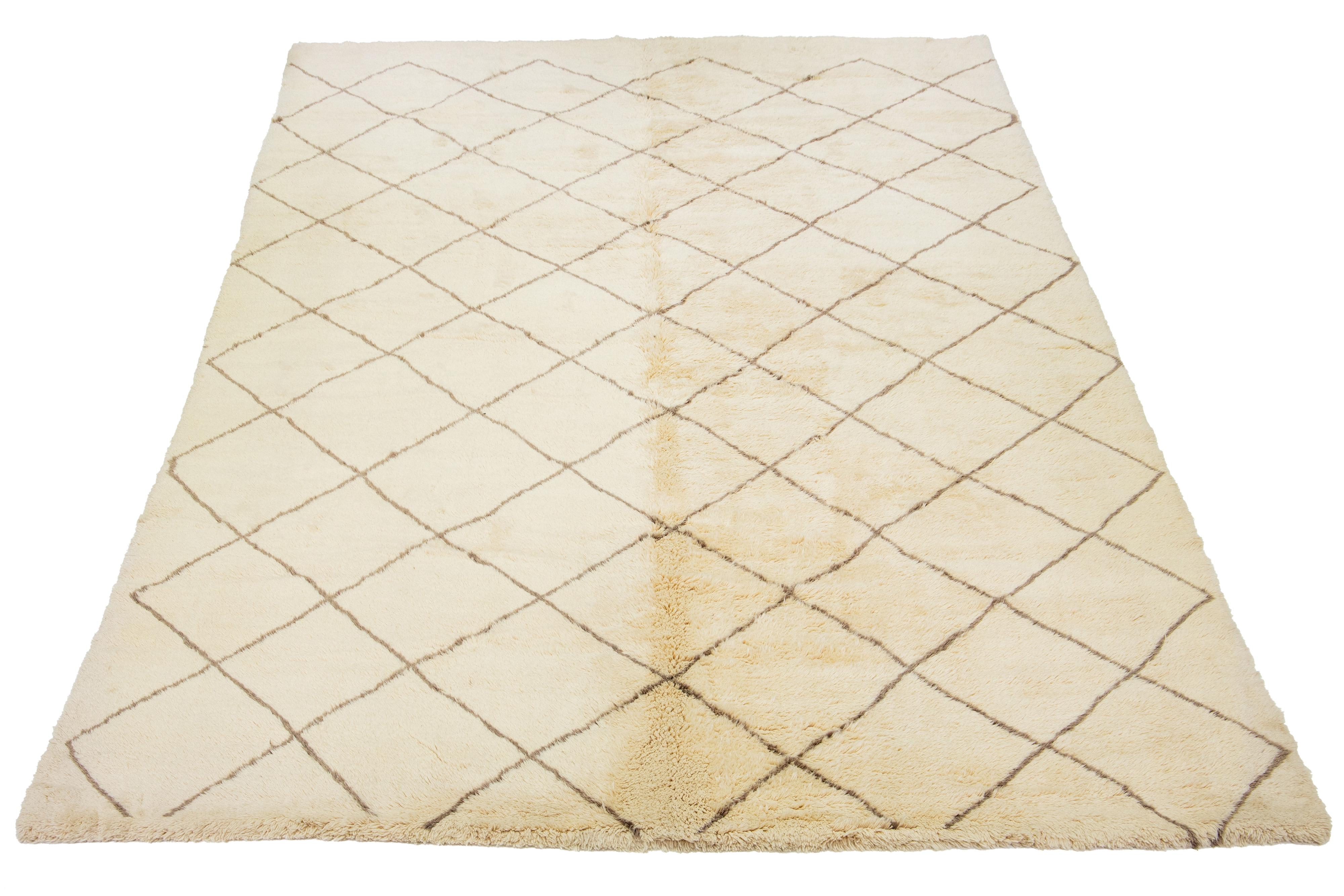 A stunning contemporary Moroccan-style wool rug, meticulously hand-knotted with a beige base and complemented by brown accents in a captivating all-over geometric pattern.

This rug measures 10'11'' x 16'11''.