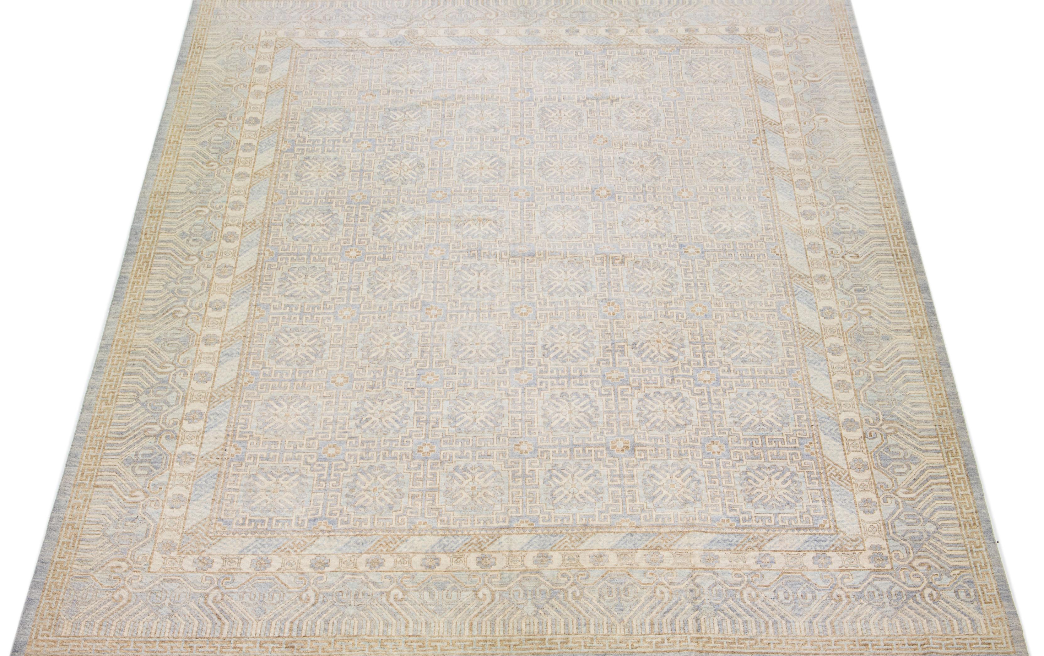 This modern wool rug from India features a striking oversize design, highlighted by a rich beige field and elaborate blue and gray floral motifs with geometric details.

This rug measure: 12' 3” x 15'.