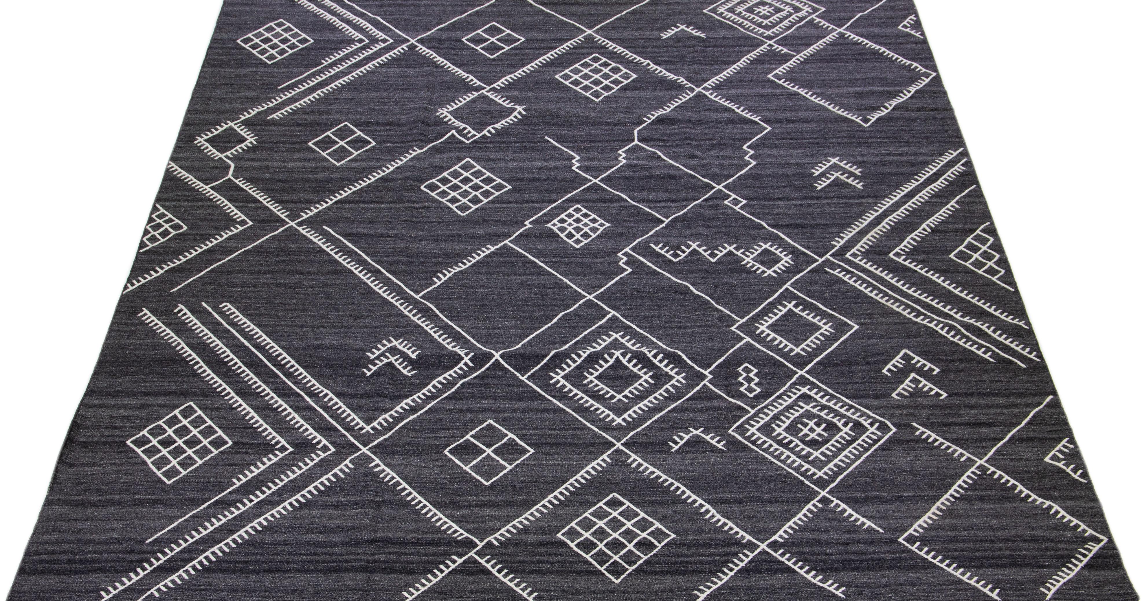 Beautiful kilim handmade wool rug with a gray-charcoal field. This custom modern flatweave rug of our Nantucket collection has white accents and a gorgeous, all-over geometric coastal design.

This rug measures: 12' x 15'.

Our rugs are