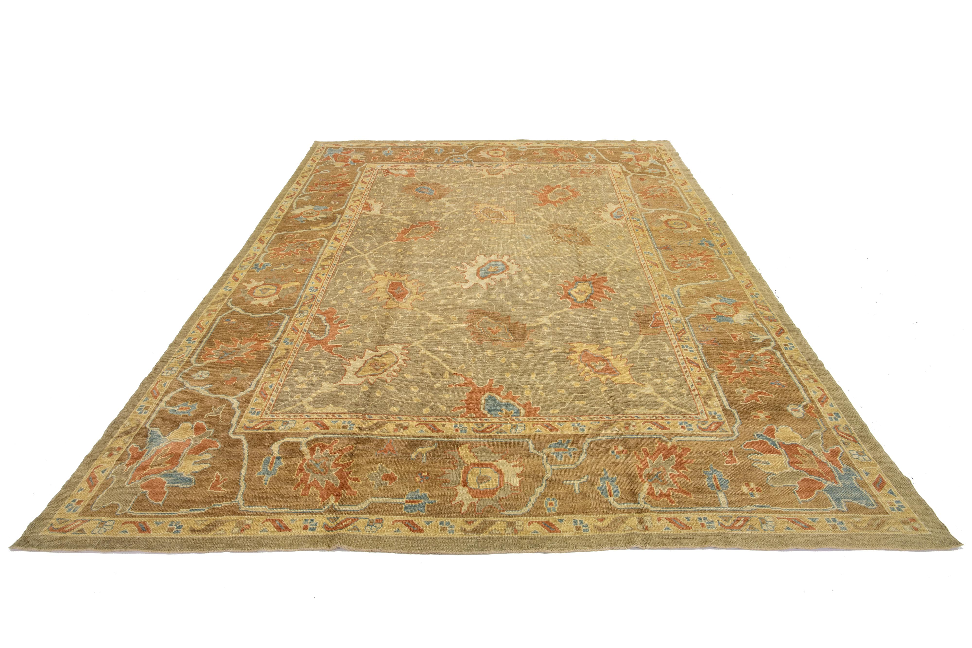 This is a hand-knotted rug showcasing a floral design. The background is tan with brown borders and is further accentuated with multi-color accents.

This rug measures 11'4