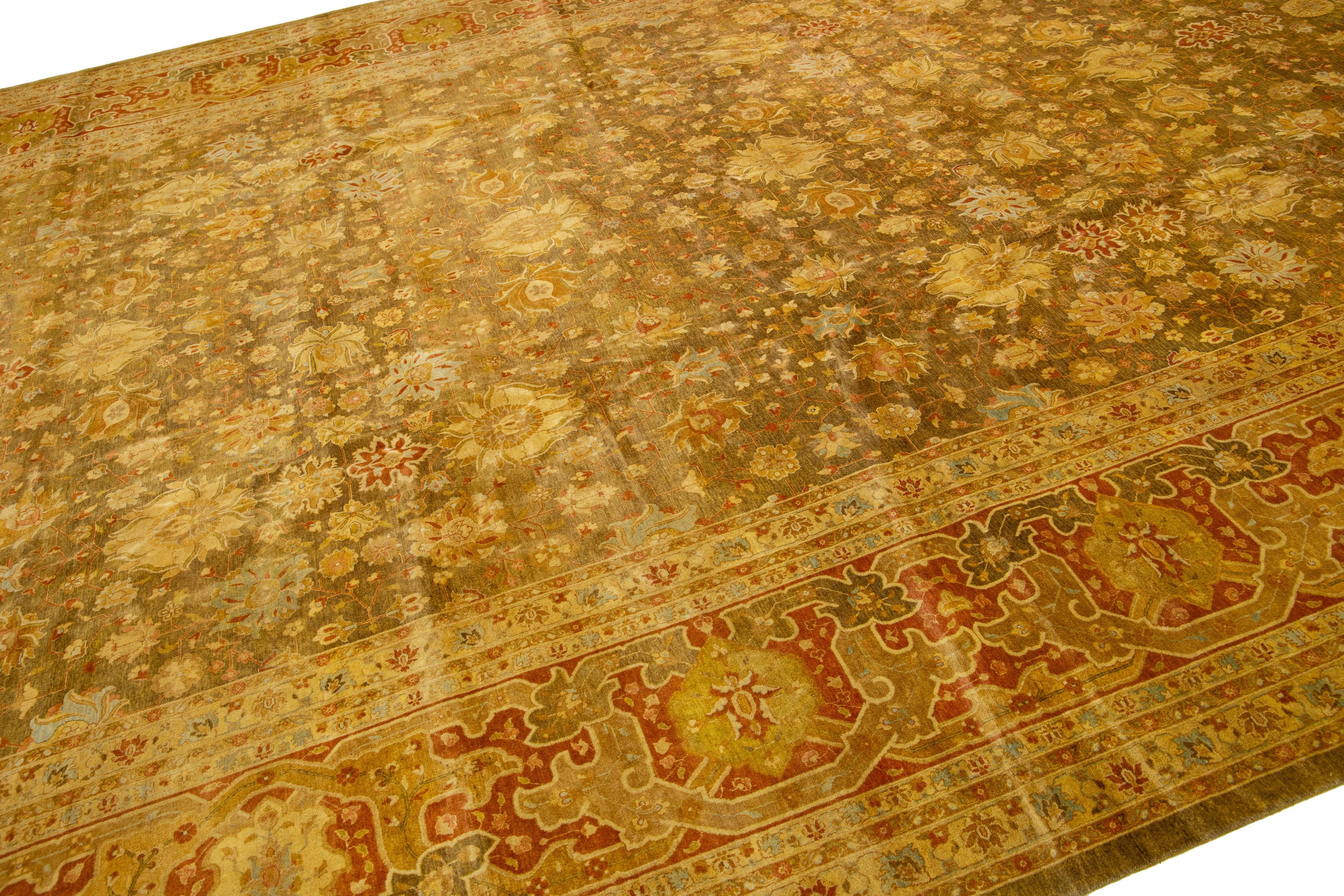 Le tapis en laine fabriqué à la main Tabriz Style présente un extraordinaire motif floral traditionnel. Le contraste saisissant entre le fond marron clair et les couleurs vertes et dorées éclatantes amplifie le design.

Ce tapis mesure 12'2