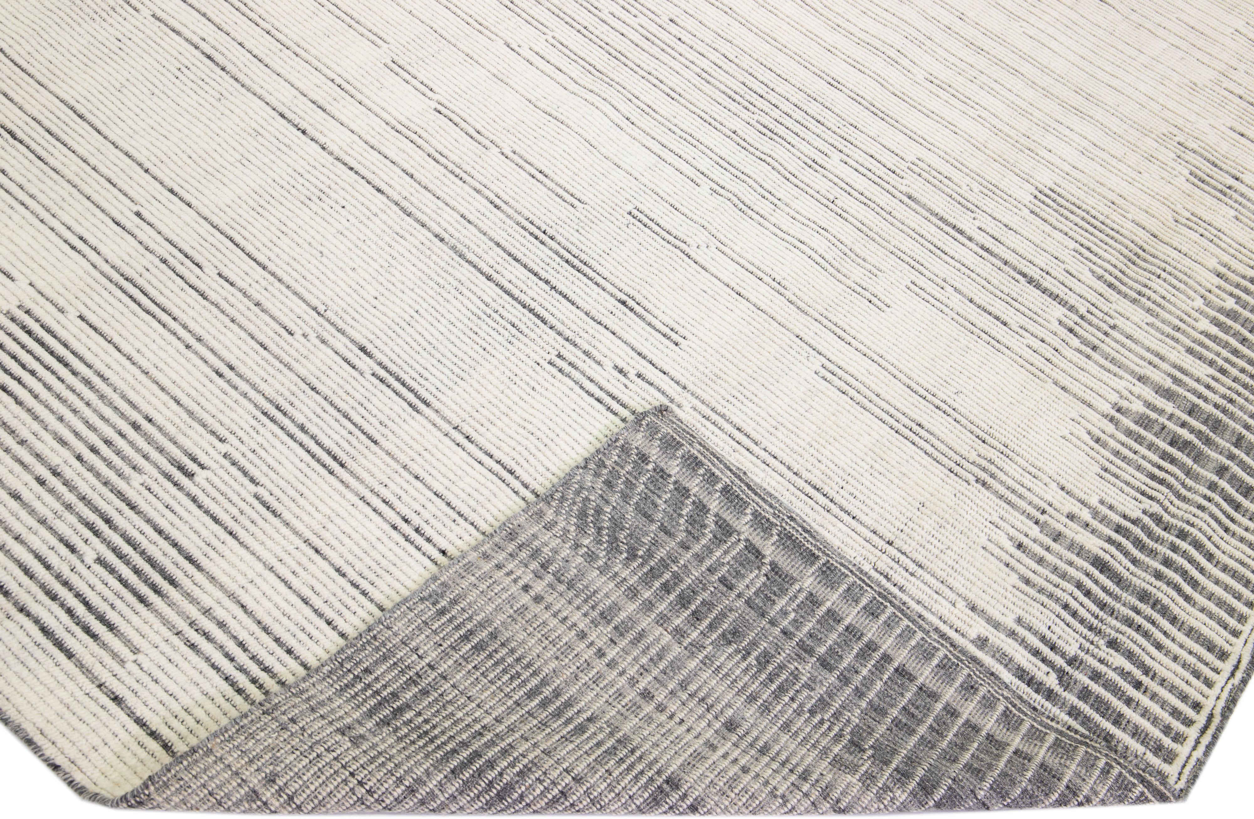Magnifique tapis moderne de style marocain en laine nouée à la main avec un champ gris clair et des accents ivoires dans un magnifique design géométrique à poils hauts.

Ce tapis mesure : 12' x 14'8