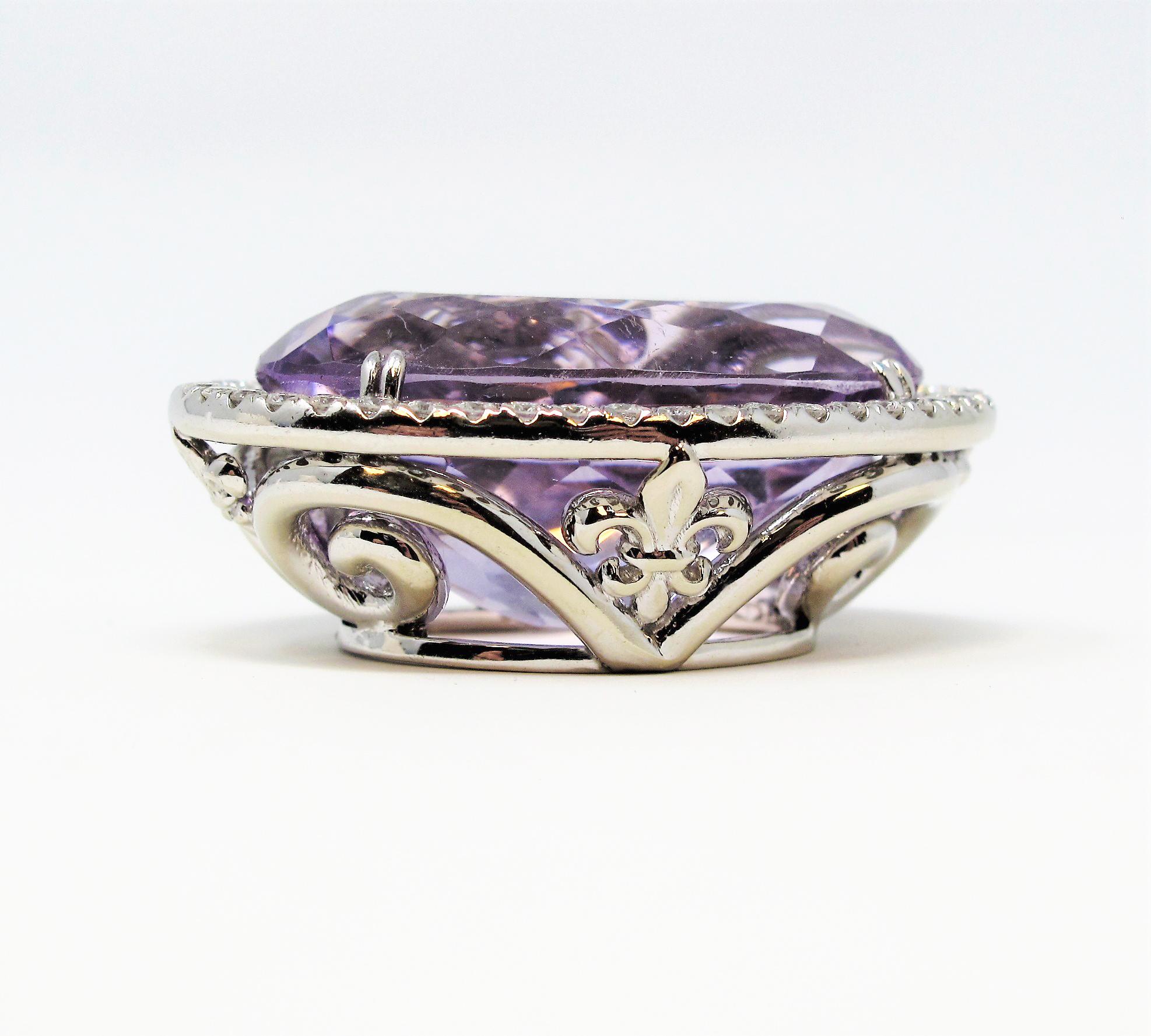 Unbelievably gorgeous amethyst and diamond halo pendant in 14 karat white gold. This massive statement piece shines with incredible brilliance, and although large in size, it appears soft and feminine against the neck with its lovely lavender