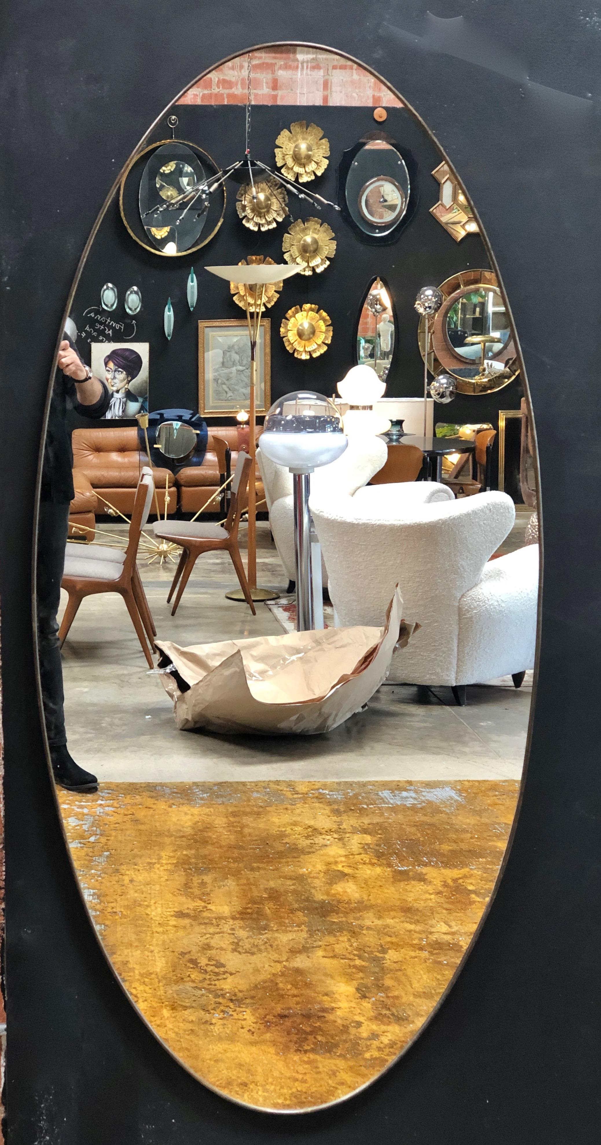 Oversize oval shaped mirror with a metallic finish, Italy, late 1960s.