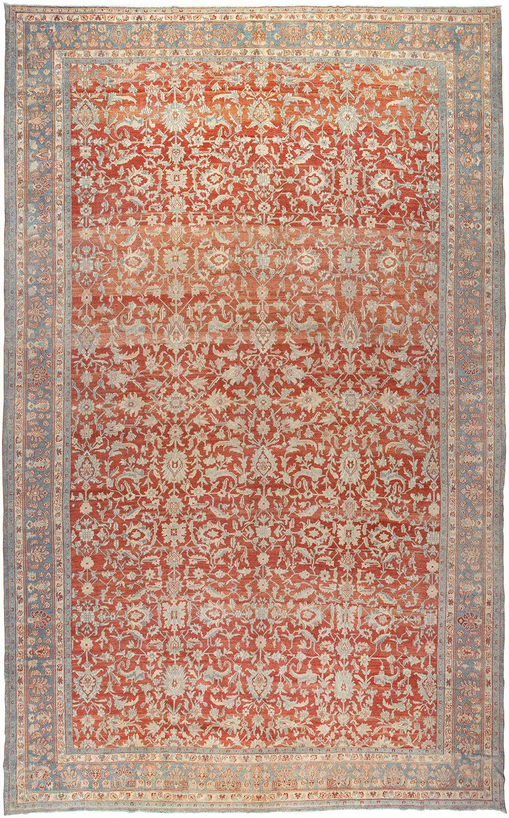 An early 20th century Persian Bibikabad oversize rug with an elegant allover design in beige, pink and gray on a soft red ground

Measures: 12'7