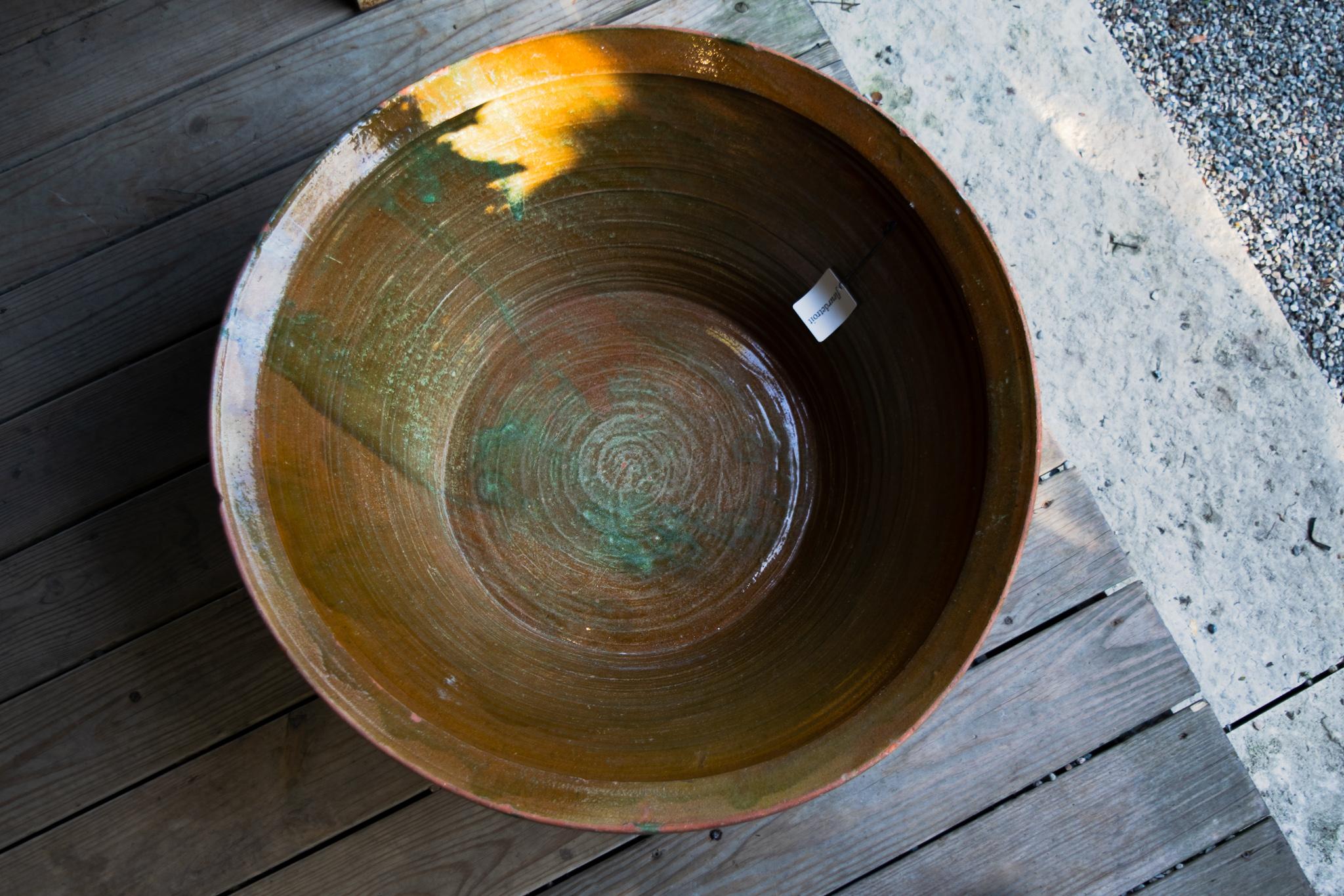 This is a beautiful antique terracotta kitchen bowl from France. Used either for proofing bread or separating dairy, the large oversized bowl indicates a kitchen that produced in large quantities and shows its wear from use fabulously. 
Beyond its