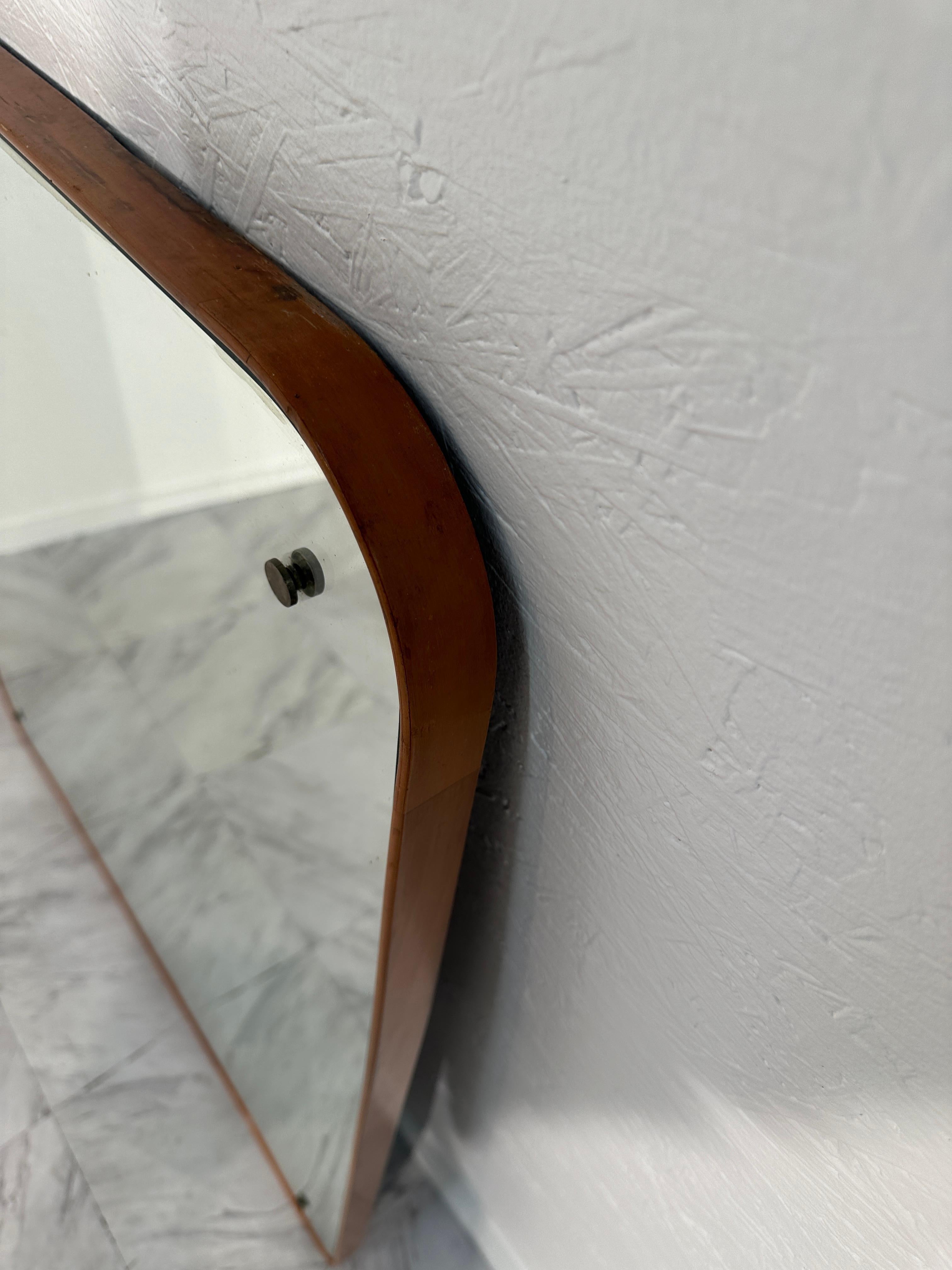 The Oversize Vintage Italian Wall Mirror from the 1970s boasts a commanding presence. Its brass frame, adorned with an original patina, adds warmth and character to any room. Crafted with Italian craftsmanship, this mirror exudes timeless elegance,