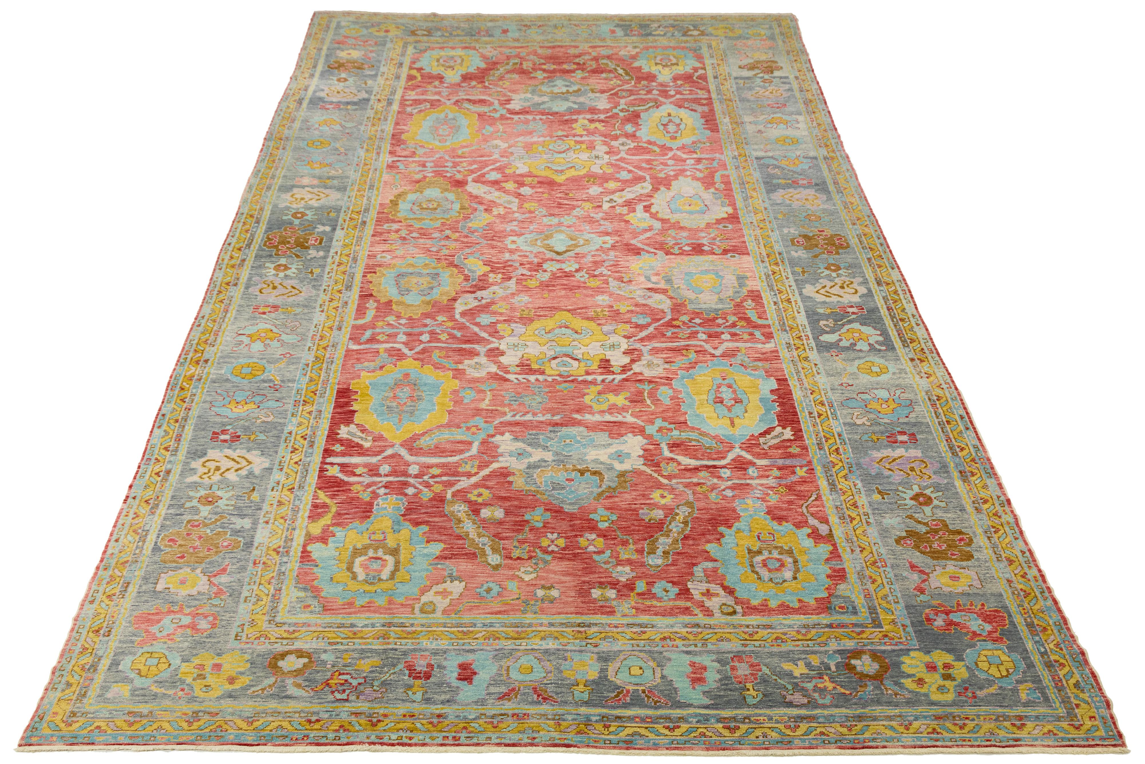 Strikingly oversized 12x25 modern Turkish Oushak rug, hand-knotted in lustrous wool with a vivid red field and intricate geometric-floral motifs. Featuring a soft abrash and a light blue border, this piece blends traditional Anatolian artistry with