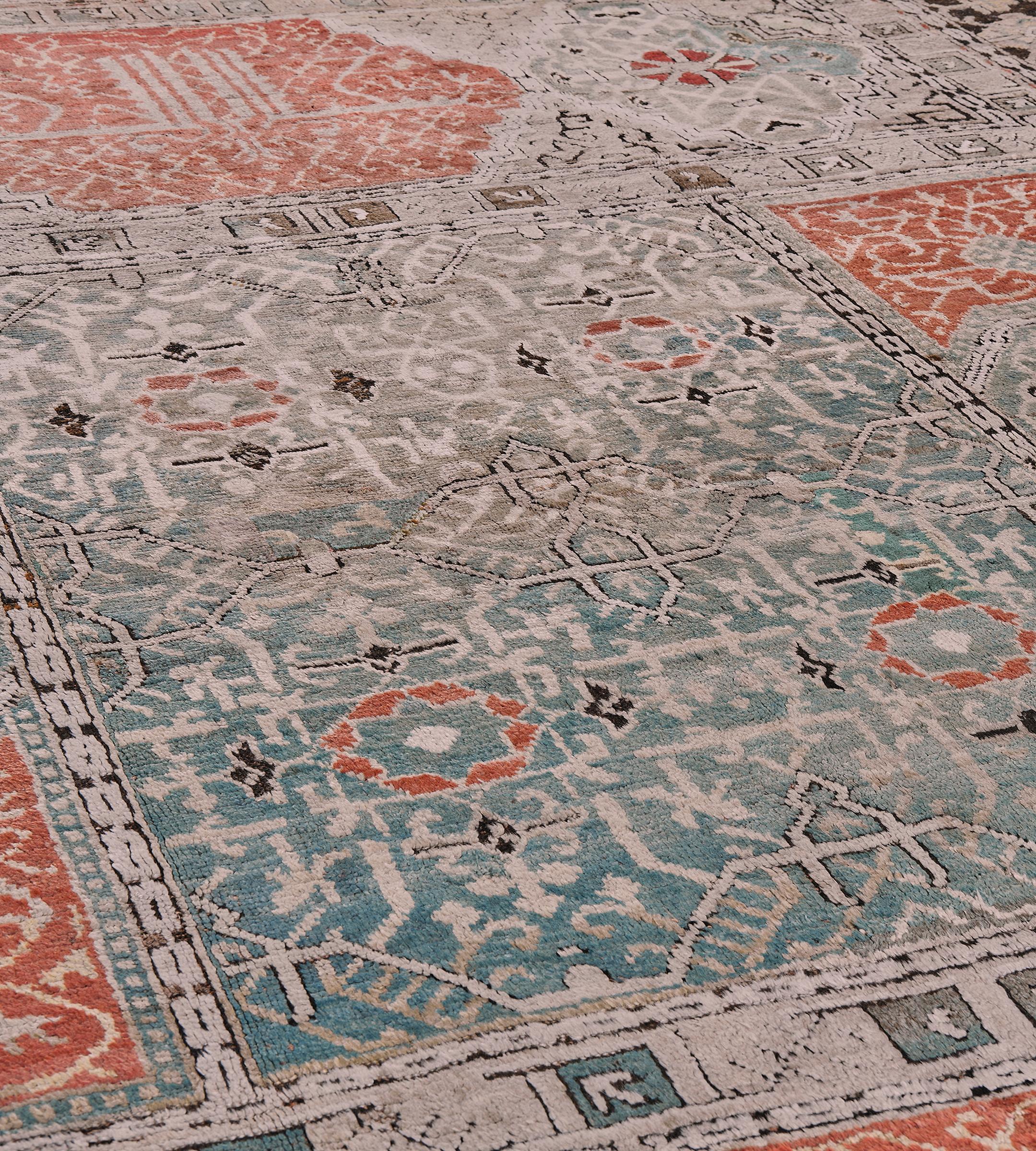 Cet ancien tapis Oushak a un champ avec un panneau central vert bouteille nuancé contenant des vignes angulaires formant quatre losanges reliés chacun contenant un panneau central rouge brique et vert bouteille nuancé, de chaque côté du panneau