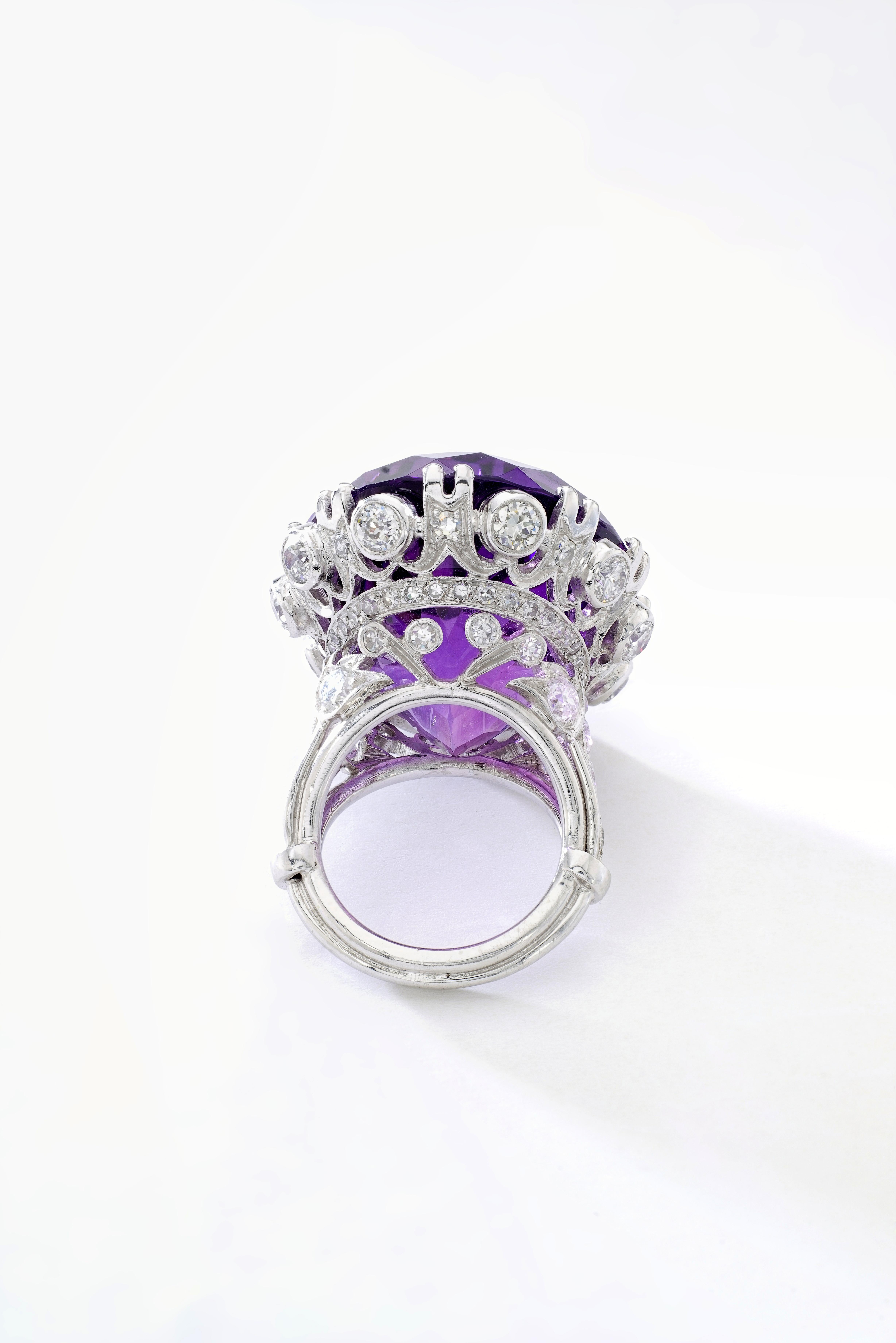 This Fantastic Oval Amethyst centering a Belle Epoque style Diamond and Platinum Ring.
Amethyst weight: approximatively 65.00 carats.

Gross weight: 33.70 grams.