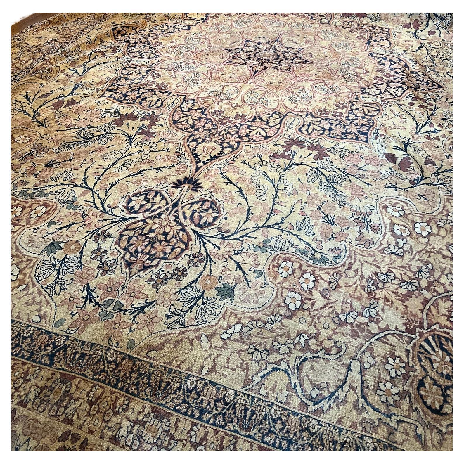 An outstanding large 19th C. Kerman Lavar rug featuring a prominent central medallion with intricate patterns and floral motifs. The rug has a rich array of floral designs, including vines, flowers, and leaves, which are intricately woven throughout