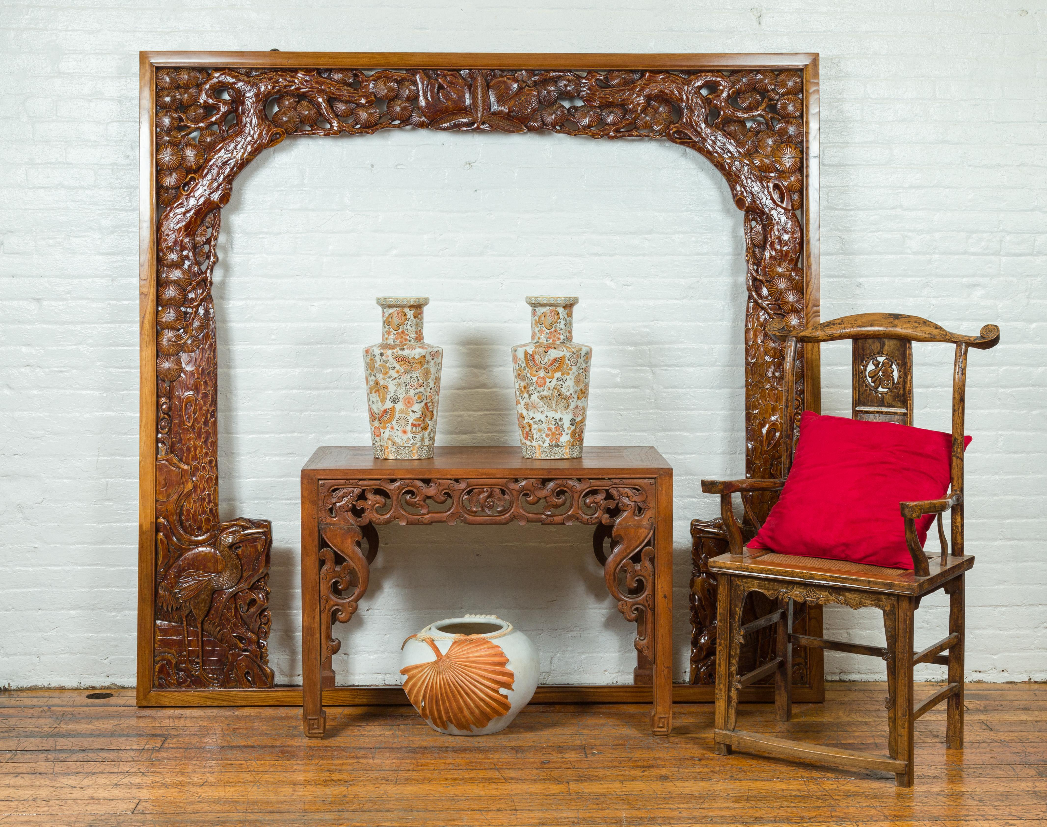 An oversized antique carved wooden frame with intricate details such as birds, flowers and tree limbs. Immerse yourself in the intricate beauty and grandeur of this oversized antique carved frame, a masterpiece of craftsmanship that captures the
