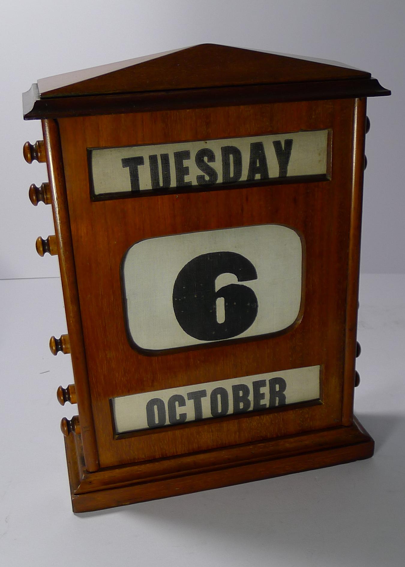It's been some time since I have had a calendar this size and even better being in sought-after mahogany.

The four knobs to each side are used to move forward and rewind the day, date and month behind the three glazed apertures. All in full