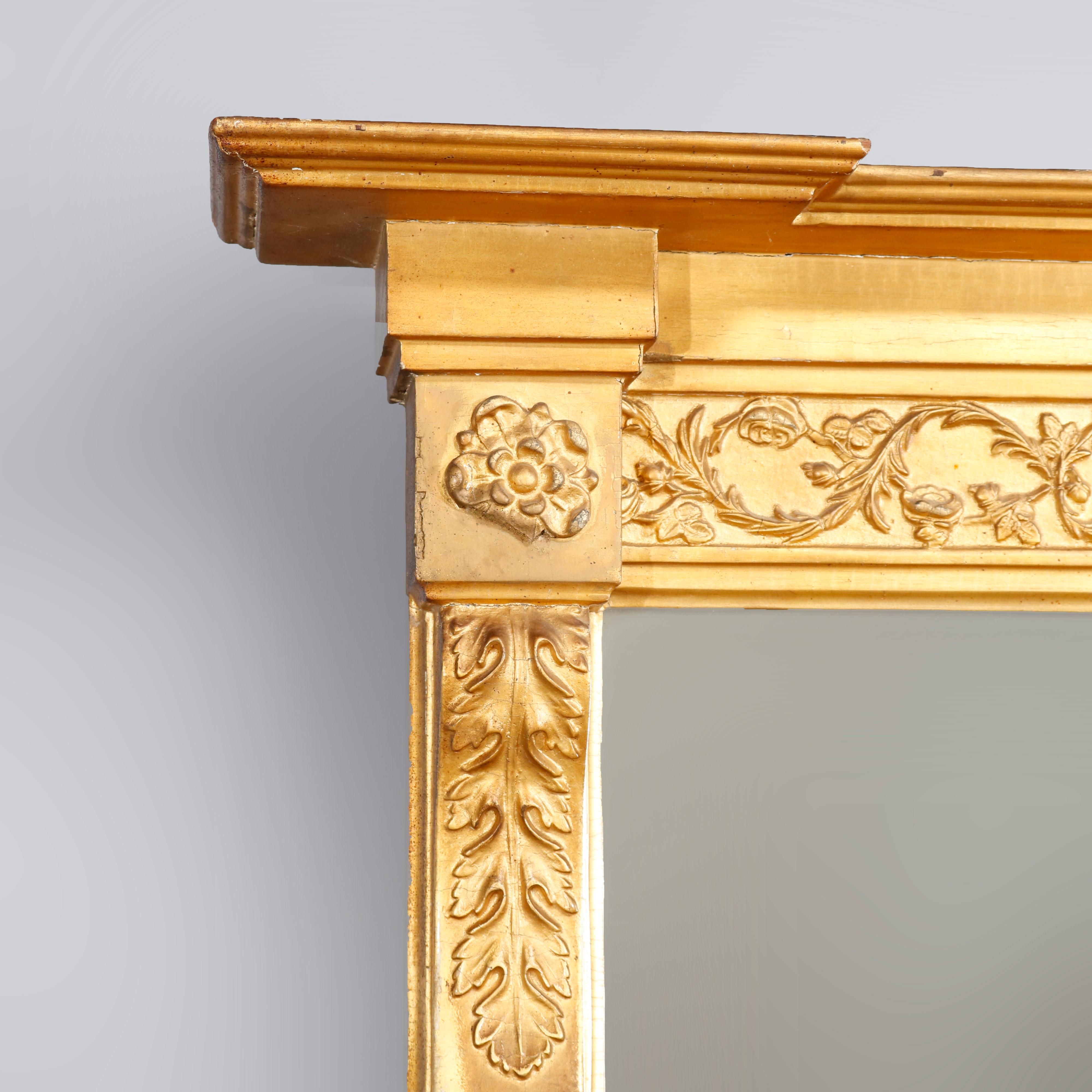 An oversized antique French Louis XVI style trumeau wall mirror offers giltwood frame with scroll, foliate, rosette and acanthus decoration with acanthus elements and twisted rope columns flanking upper and lower mirror panels, circa
