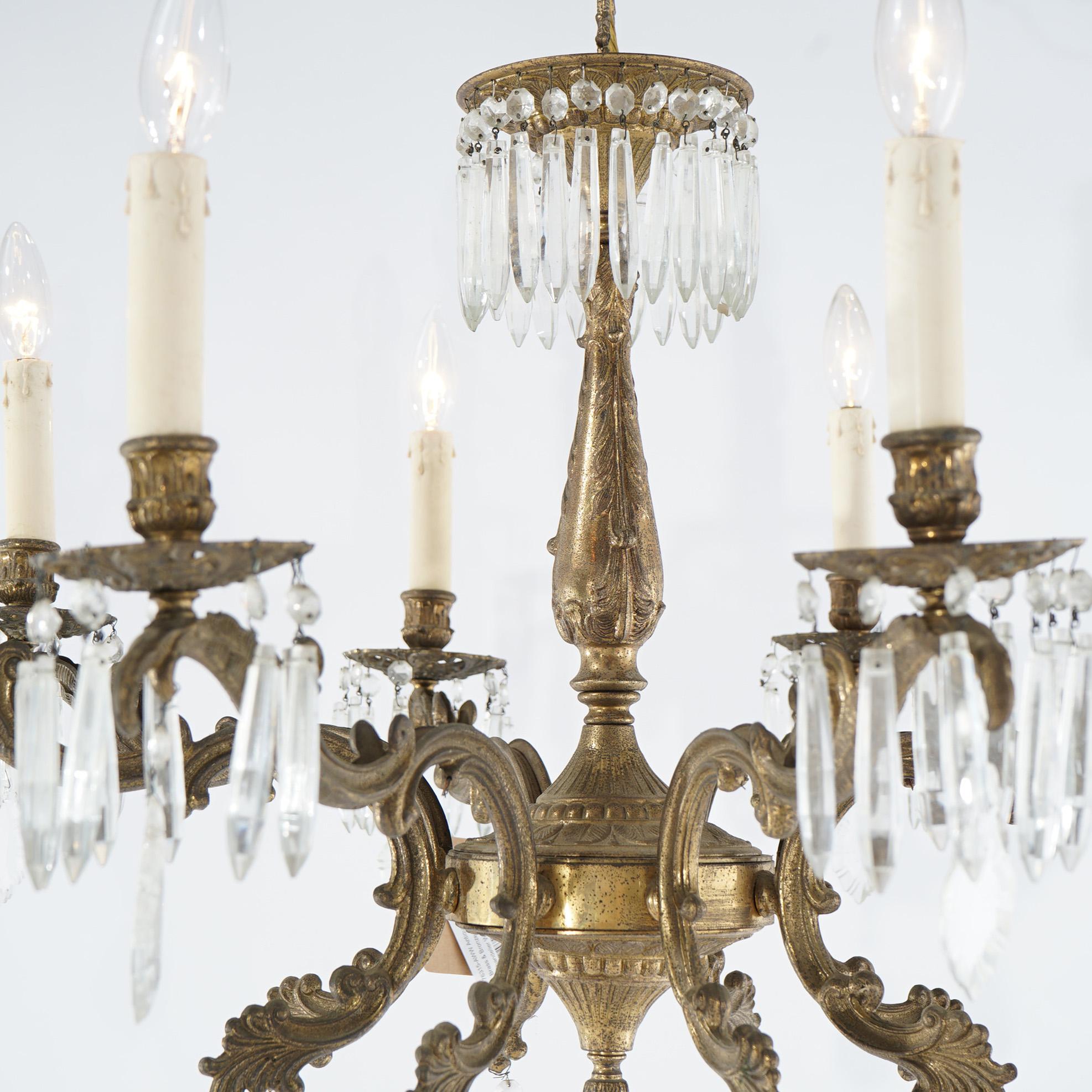 An oversized antique French style chandelier offers brass and bronze frame with eight scroll and foliate form arms terminating in candle lights; cut crystals throughout; c1940

Measures - 32