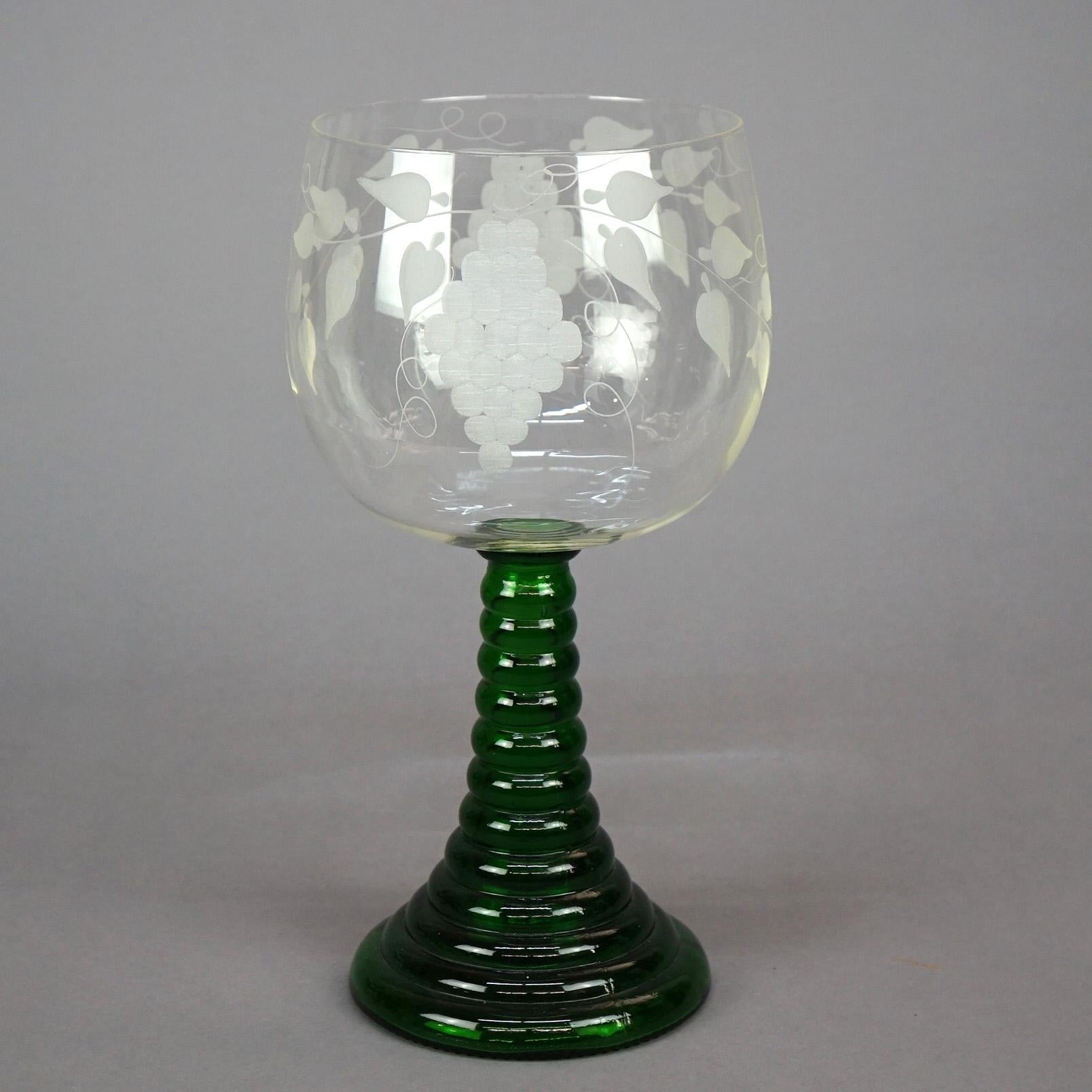 An antique and large chalice offers Bohemian glass construction with colorless bowl having etched grape and vine design and raised on flared emerald green glass stem, circa 1900.

Measures - 17