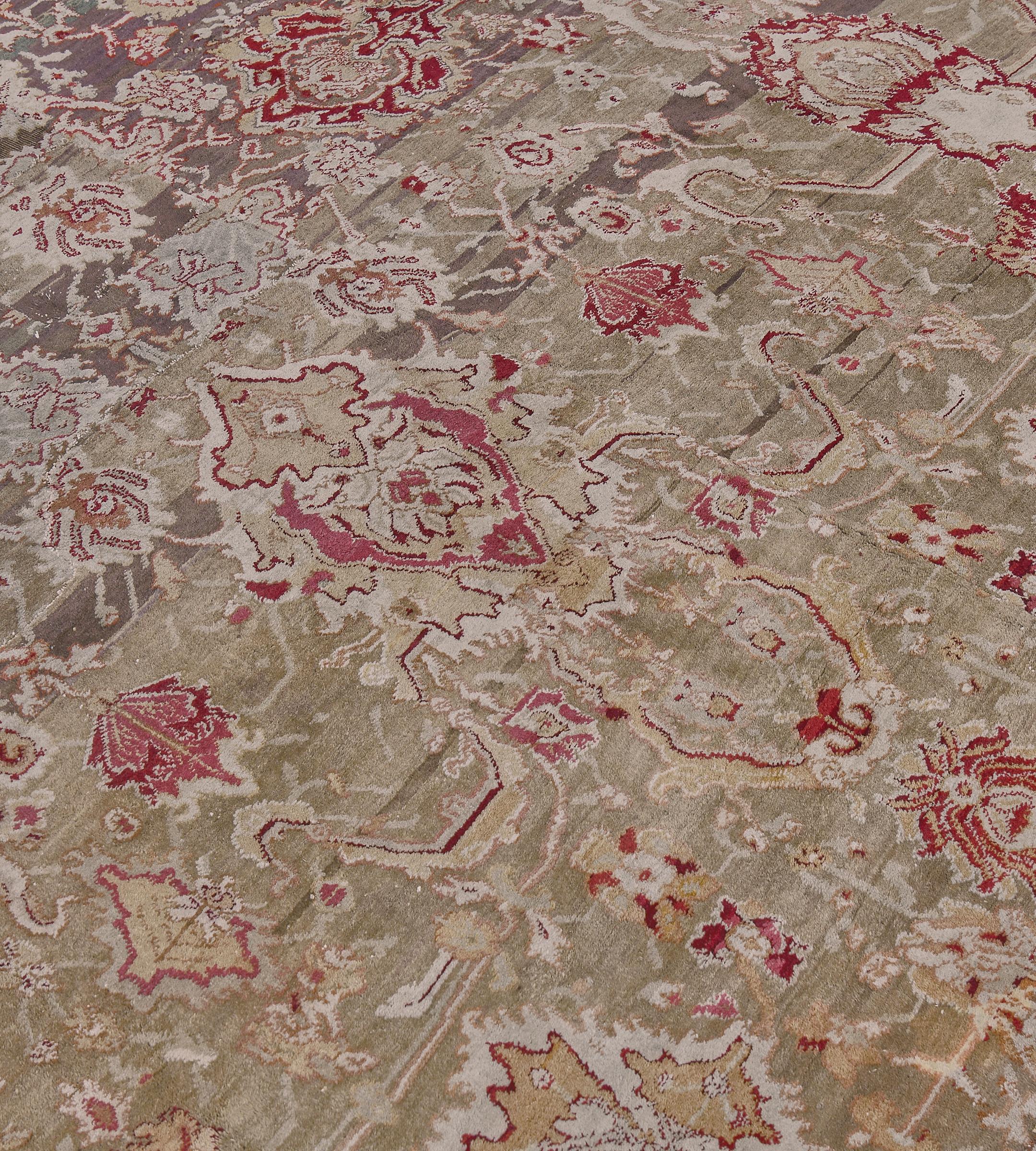 This antique, oversized hand-woven Agra rug has  a central green field of intricate vine forming lattice issues by palmette and floral icons, in a burgundy scrolling palmette border, between refined floral vine stripes.

About Agra Rugs:
Agra rugs,