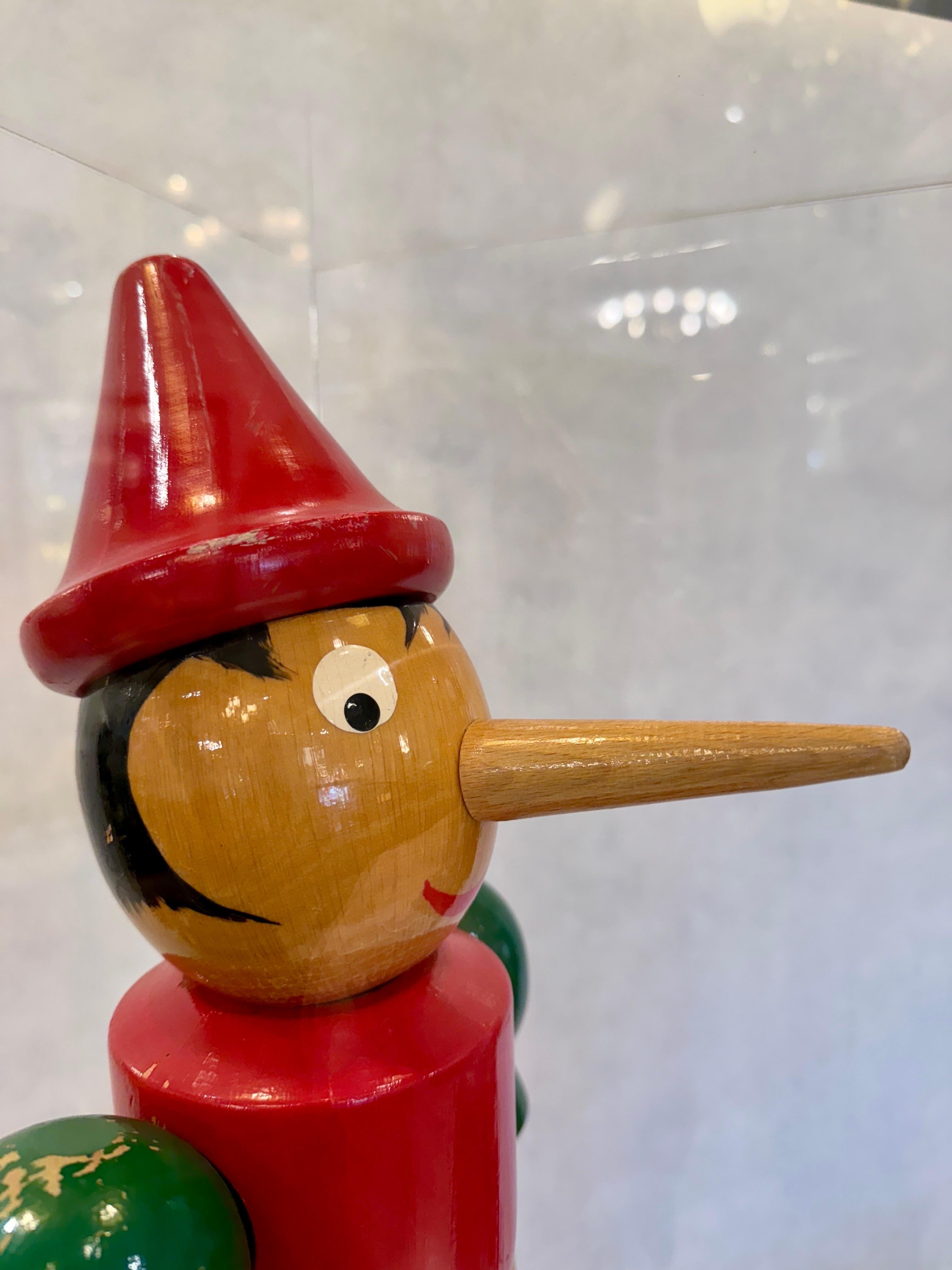 Dies ist ein Meisterwerk für sich, ein handgeschnitztes und handbemaltes überdimensionales Holzspielzeug von Pinocchio, dem Holzspielzeug, das ein echter Junge wurde. Dieser Schatz der Zeit wurde in einer speziell angefertigten Acryl-Display-Box mit