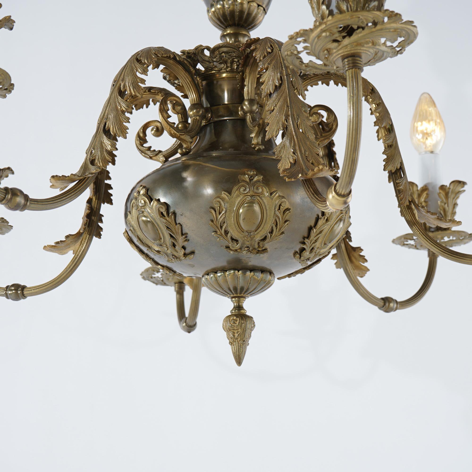 A large French Louis XV style chandelier offers brass and bronze construction with font having stylized shield form medallions and six scrolled acanthus arms terminating in candle lights, c1940

Measures - 45