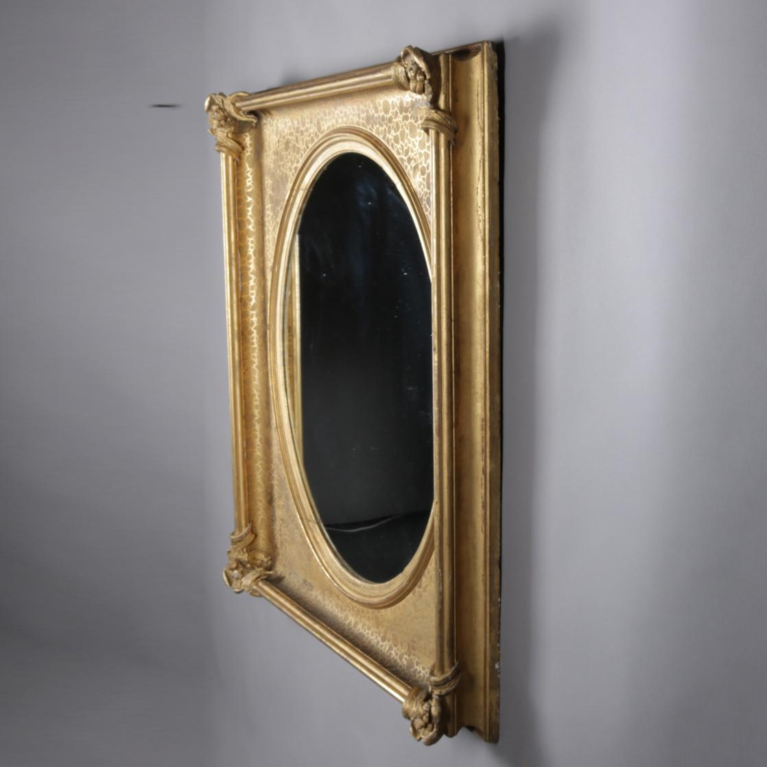 An oversized and antique giltwood portrait mirror features rectangular form with corners of fruit and nuts, interior is modeled gilt with an oval presentation window, mirror plate is newer, circa 1880.


Measures: Overall 39.75