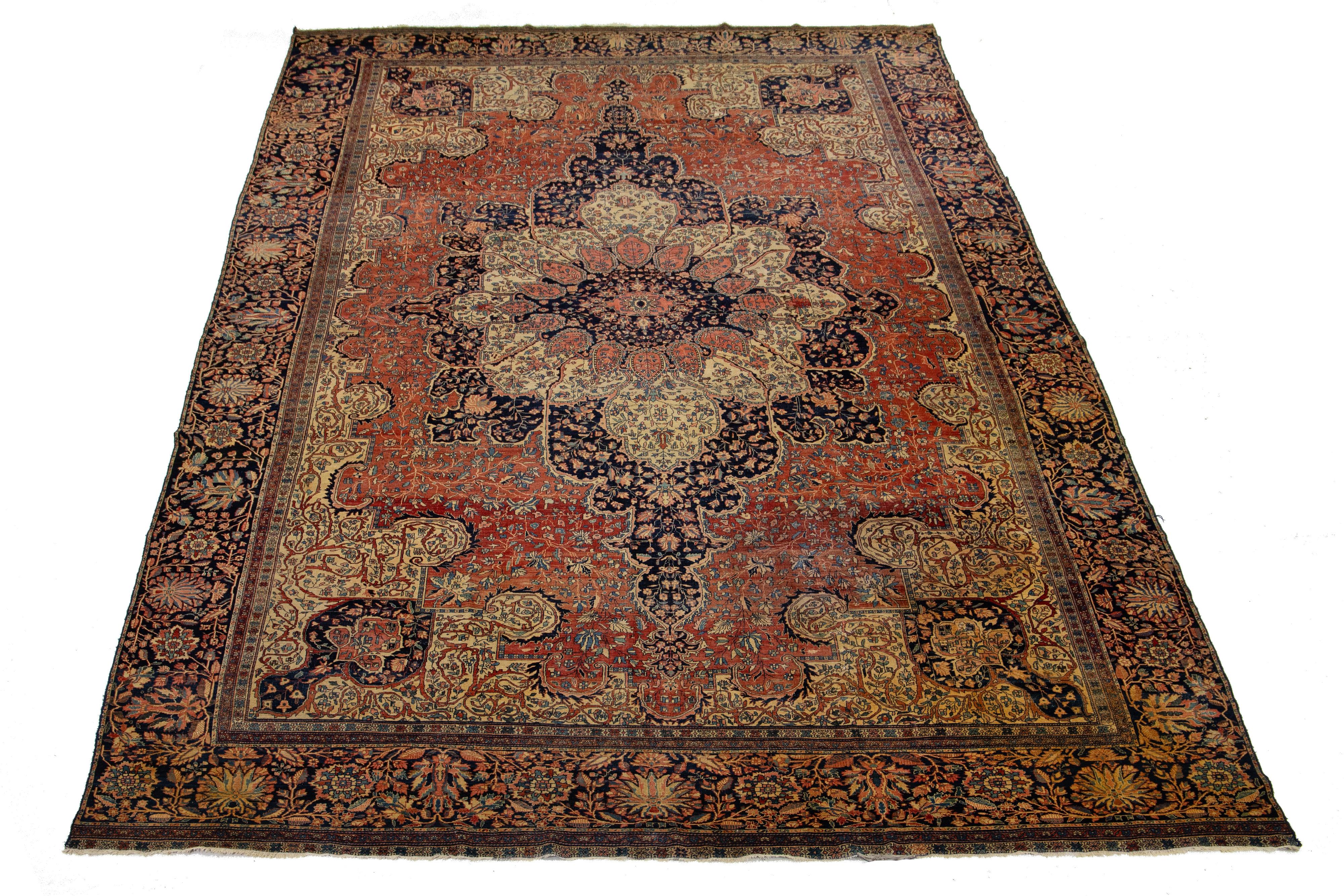 Ce tapis Sarouk Farahan surdimensionné en laine nouée à la main présente un champ rouge, un cadre bleu foncé et des accents multicolores, mettant en valeur un motif floral all-over classique.

Ce tapis mesure 12'10