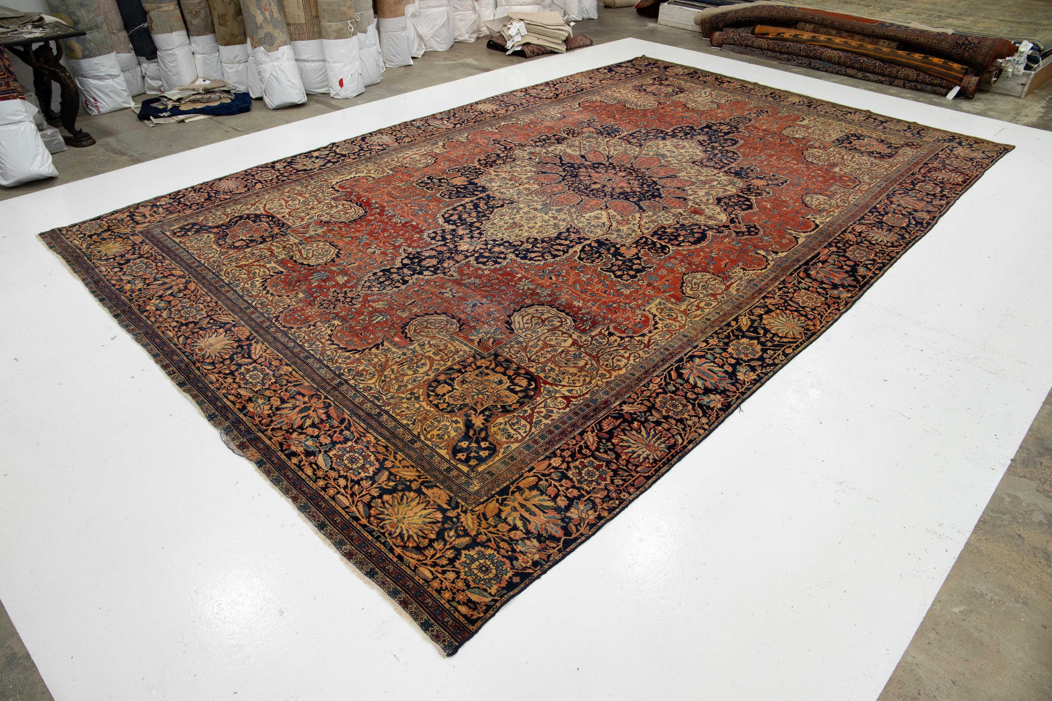 Sarouk Farahan Tapis persan ancien Farahan surdimensionné en laine rouge avec un motif de médaillon en vente
