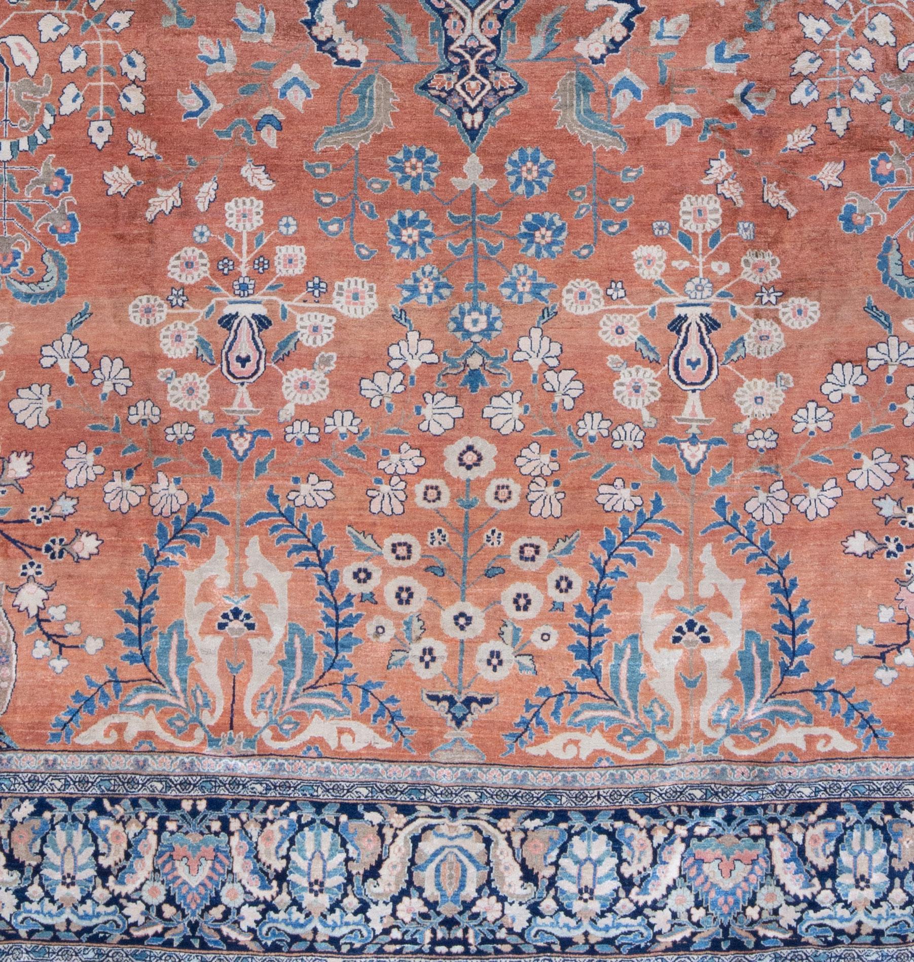 A late 19th Century Ferahan Sarouk a with coral field color and beautiful shades pinks, greens and indigo and navy blue. Delicate floral motifs with meandering vines. A very finely woven carpet with a dense, low wool pile. In beautiful condition