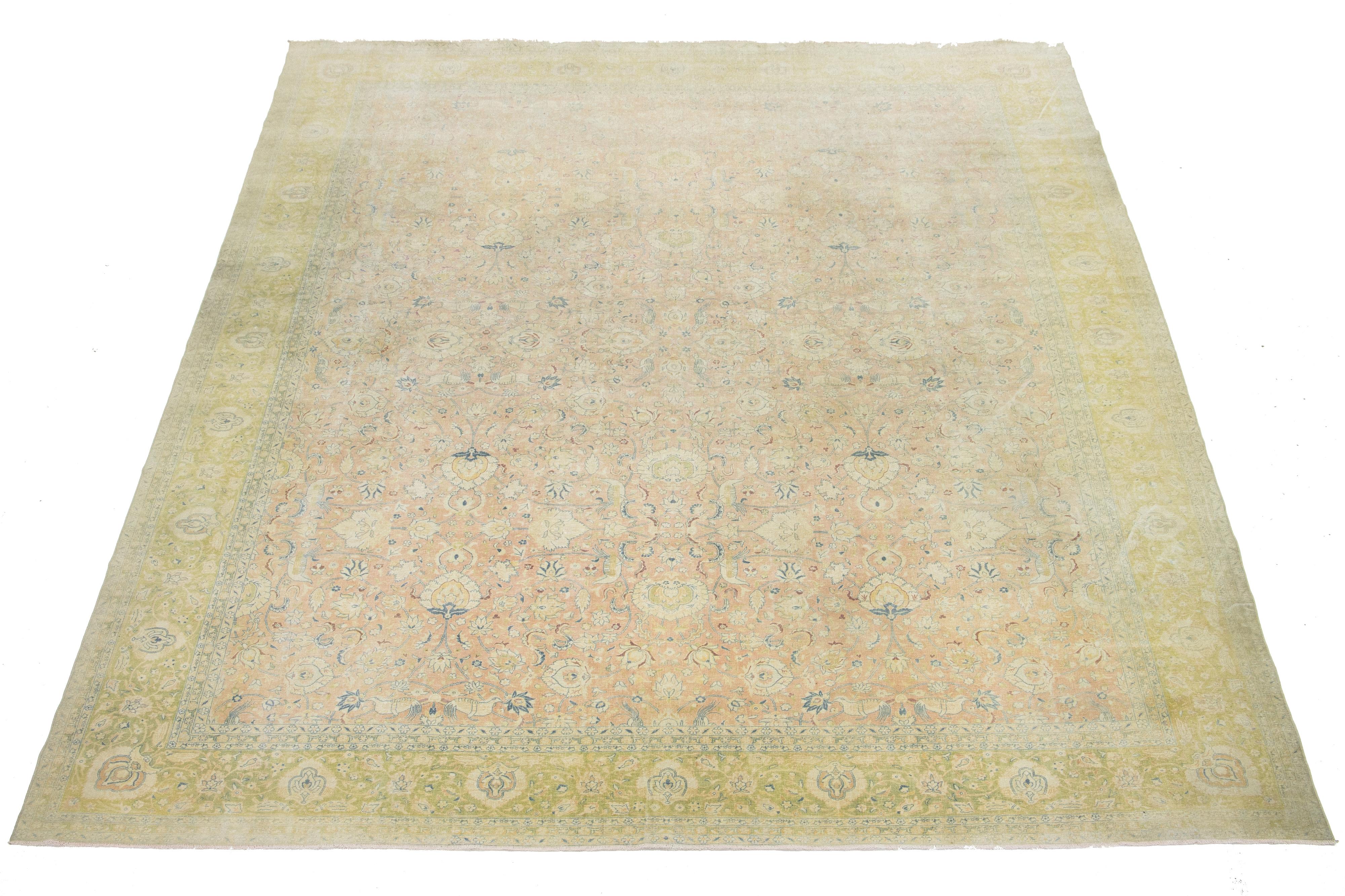 Scopri lo squisito charme di questo antico tappeto Tabriz in lana oversize annodato a mano. Il suo accattivante campo di colore marrone e pesca mostra un intricato motivo all-over, splendidamente completato da sfumature di verde e blu.

Questo