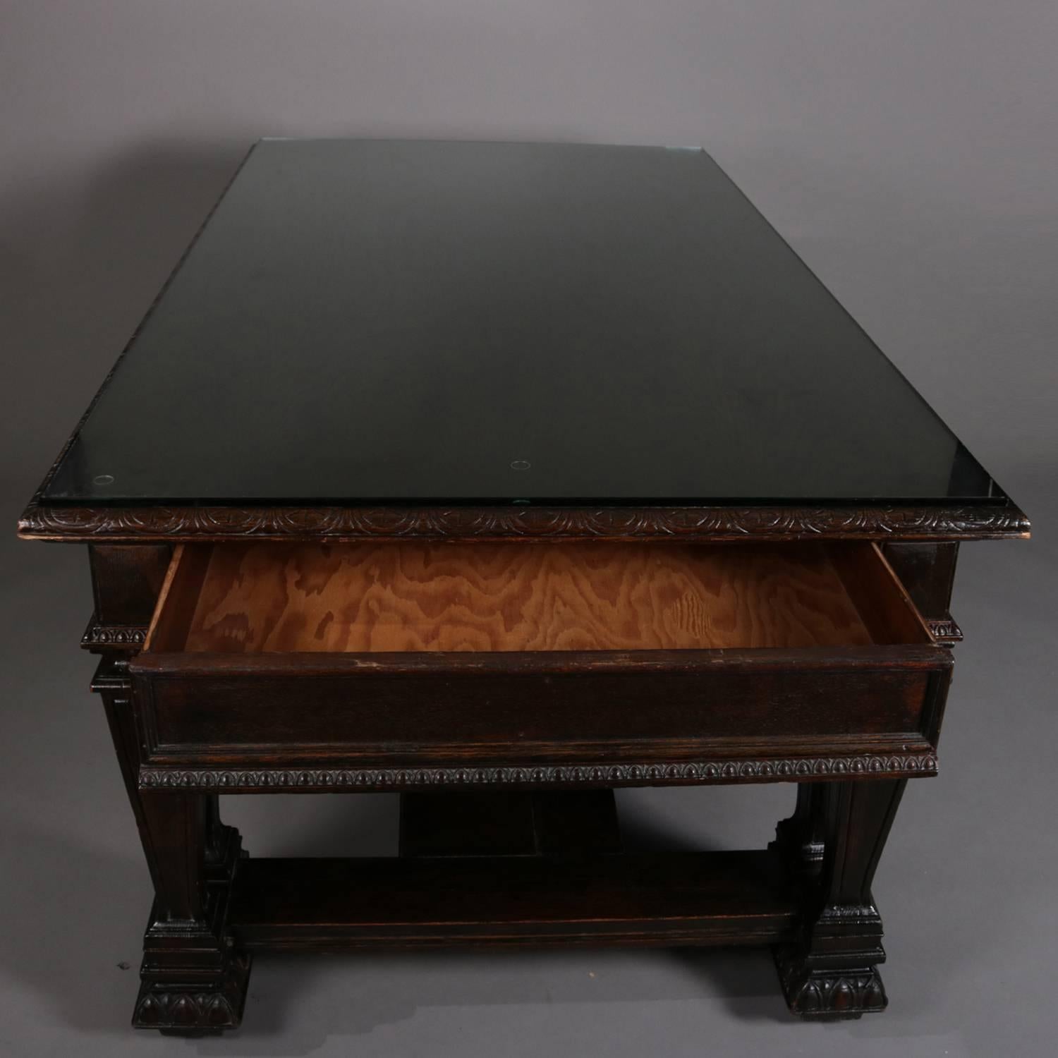 Oversized antique Renaissance Revival oak library table features egg and dart trimming, two drawers, and is raised on eight squared and tapered column form incised legs, protective glass top included, 19th century

Measures: 31