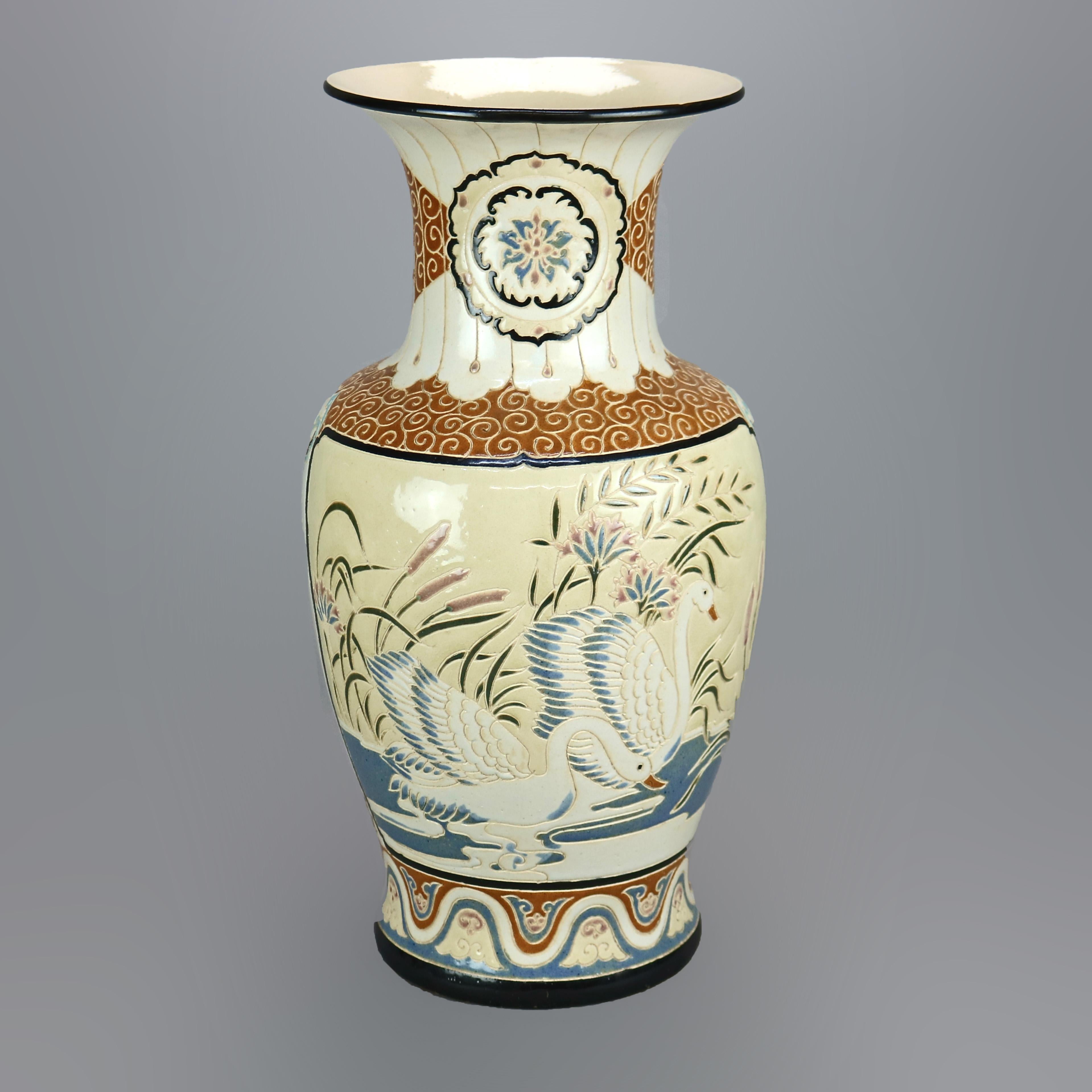 An antique and large pottery vase in the manner of Satsuma offers pottery construction with engraved and hand painted pond scene with swans and stylized cloud elements, c1920

Measures - 20.25''H X 9.75''W X 9.75''D.

Catalogue Note: Ask about