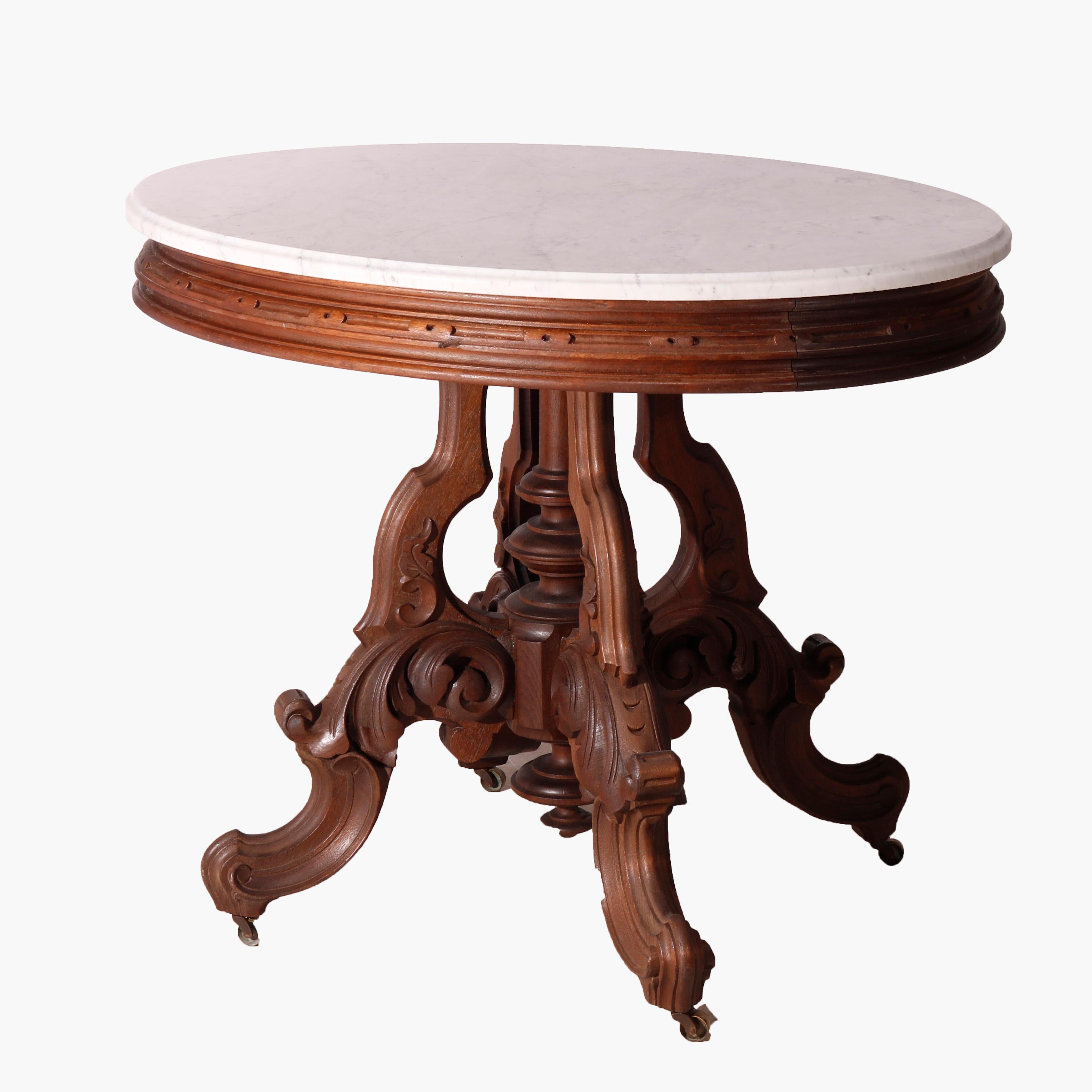 An antique Victorian Brooks parlor table offers beveled marble surmounting a carved walnut base raised on stylized scroll and foliate form legs, circa 1890

Measures - 30
