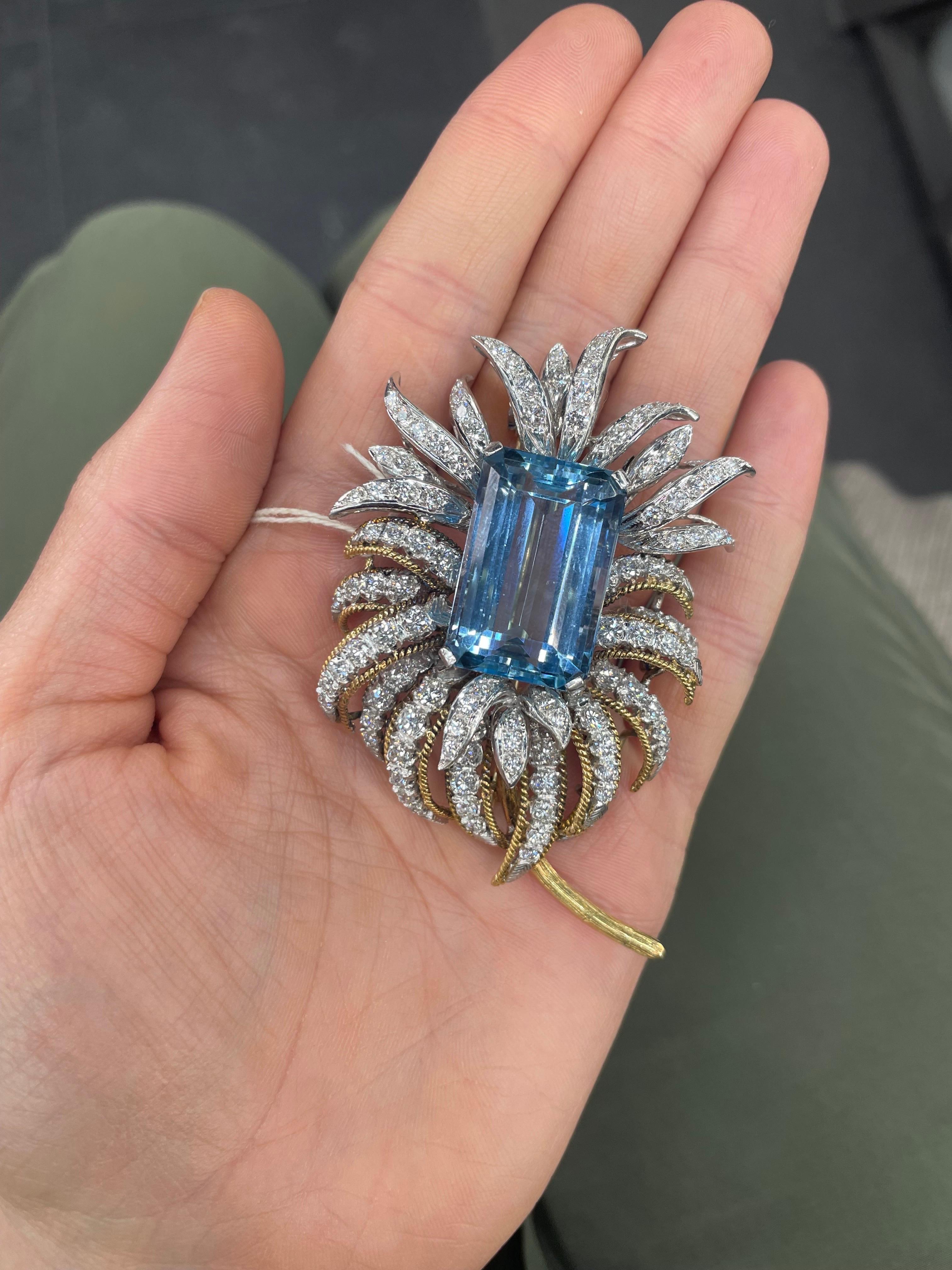 One oversized floral pin featuring an Emerald Cut Aquamarine weighing 38 Carats flanked with numerous round diamonds weighing approximately 6.50 carats, in 18 Karat Yellow Gold. 