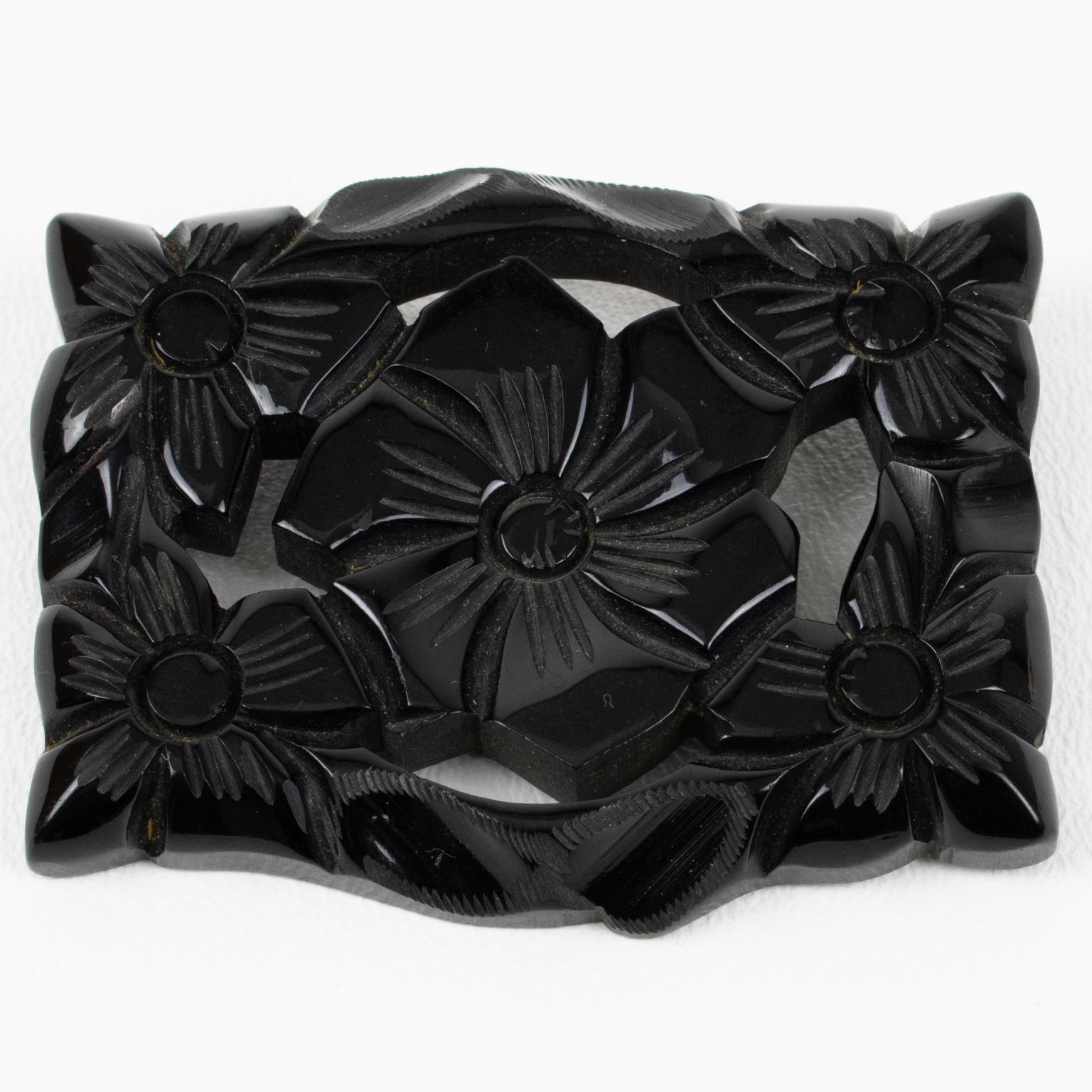 Gorgeous carved Bakelite pin brooch. Oversized rectangular and dimensional shape with deeply carved and see thru floral design. True licorice black color. Regular closing clasp. There is no visible maker's mark. 
Measurements: 2.63 in. wide (6.7 cm)
