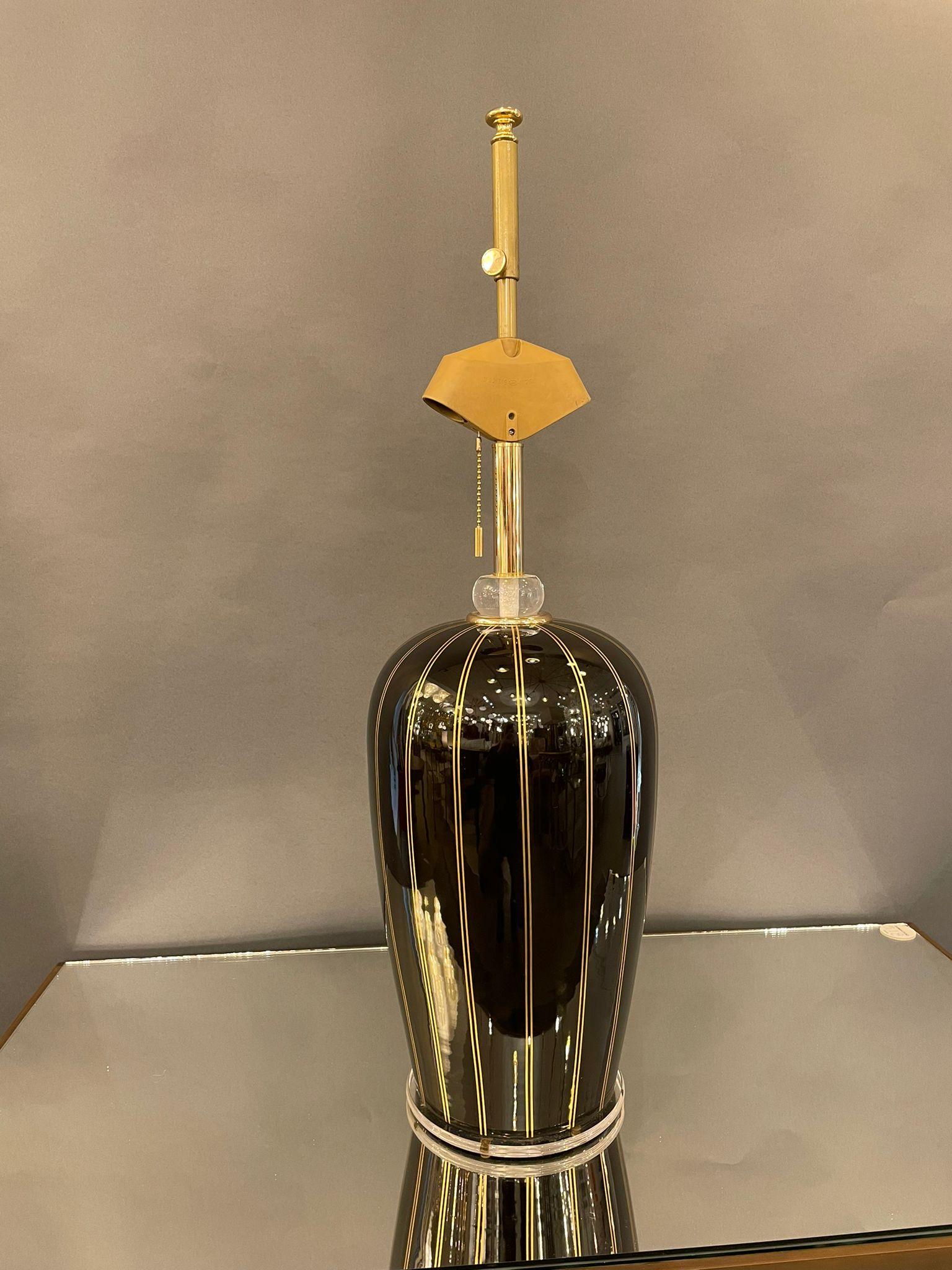Beautiful Italian table lamp in black Murano glass with Lucite base. Fine hand painted gold lines define the elegant shape.