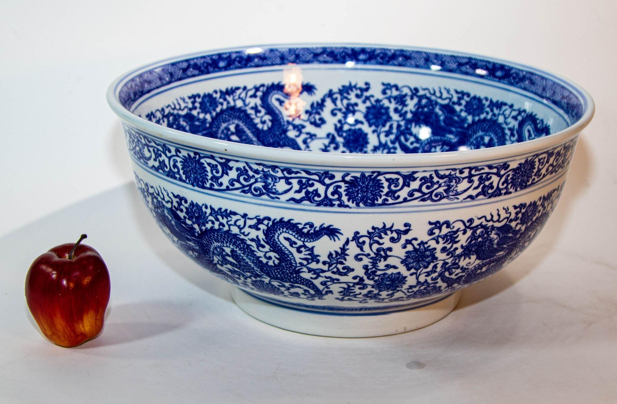 Vintage Oversized Blue and White Porcelain Chinese Dragons Bowl.
This beautiful Chinese bowl is hand painted in blue and white with a beautiful scene of a dragons.
It features blue and white floral design with a dragon in the center, and dragons